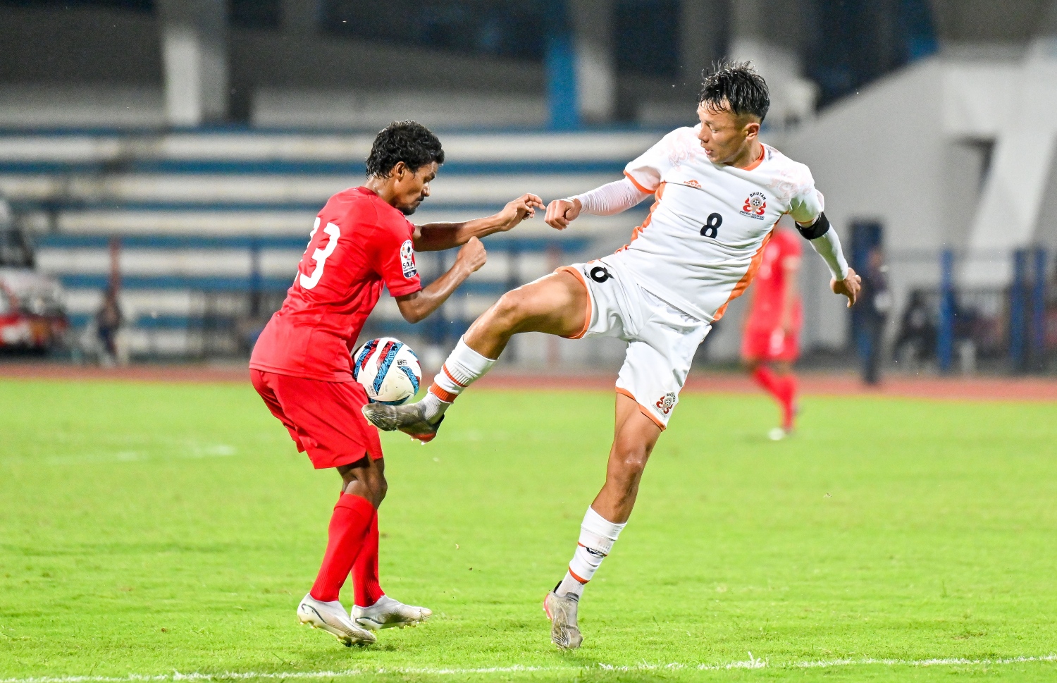 ސާފް ޗެމްޕިއަންޝިޕްގައި އިންޑިއާގެ ބެންގަލޫރުގެ ސްރީ ކަންތީވާ ސްޓޭޑިއަމްގައި ޖޫން 22، 2023 ގައި ބޫޓާނާ ދެކޮޅަށް ކުޅެ ރާއްޖެ 2-0 އިން މޮލުވި މެޗުގައި ބޫޓާން ކުޅުންތެރިޔަކު ބޯޅަ ހޯދަން މަސައްކަތްކުރަނީ -- ފޮޓޯ: ފަޔާޒު މޫސާ | މިހާރު