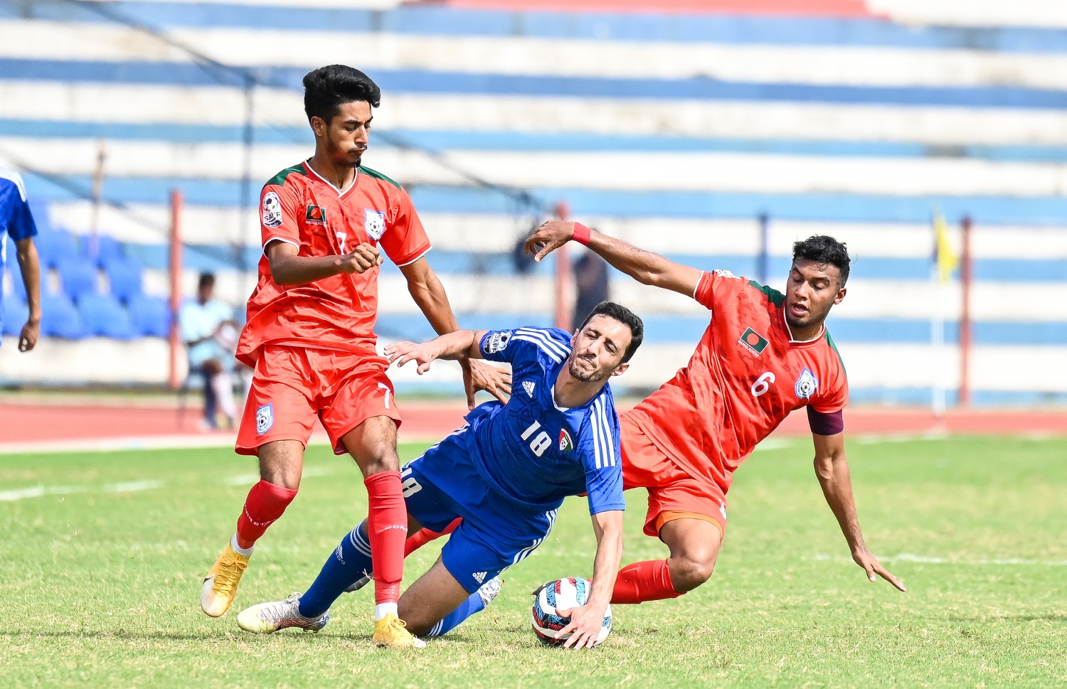 ކުވައިތުގެ ކުޅުންތެރިޔަކު ބޯޅަ ހިފައިގެން ކުރިއަށް ދާން މަސައްކަތްކުރާއިރު ބަންގްލަދޭޝްގެ ދެ ކުޅުންތެރިޔަކު ކުވައިތު ޓީމުގެ ކުޅުންތެރިޔާއަށް ޓެކްލްކޮށް ވައްޓާލަނީ -- ފޮޓޯ: ފަޔާޒު މޫސާ | މިހާރު