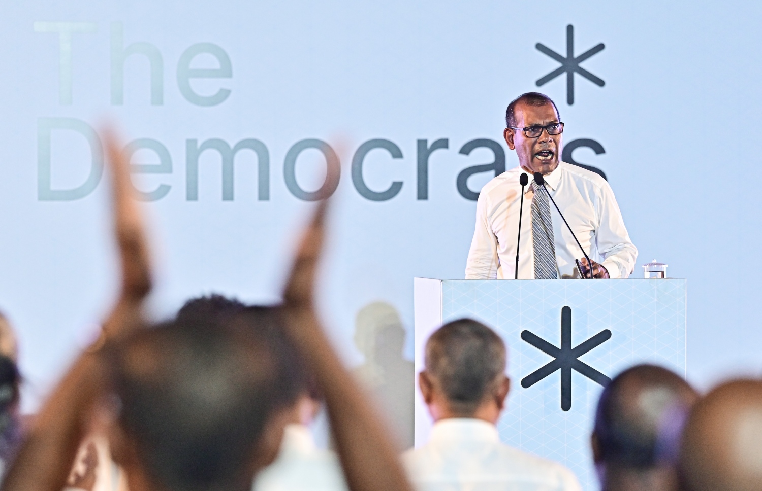 ޑިމޮކްރެޓްސްގެ ޖަލްސާއެއްގައި ނަޝީދު ވާހަކަ ދައްކަވަނީ: ގާނާއަށް ދިރިއުޅުން ބަދަލުކުރެއްވިޔަސް ޑިމޮކްރެޓްސްގެ ކެމްޕޭނަށް މާލެވަޑައިގެން ކެންޑިޑޭޓުންނަށް ތާއީދު ހޯދައިދެއްވަން މަސައްކަތް ކުރެއްވި. -- ފޮޓޯ | މިހާރު