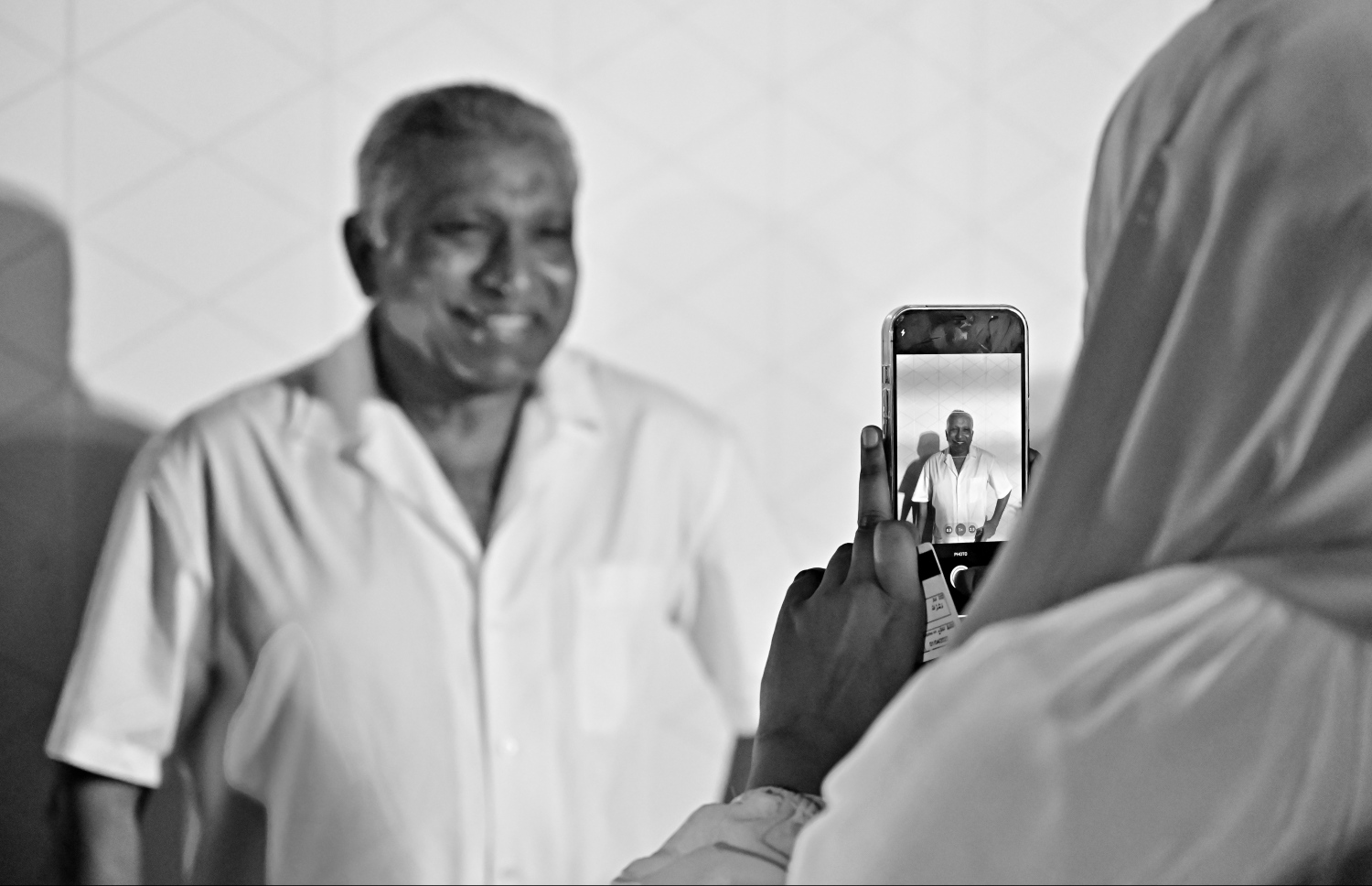 ކުރީގެ ރައީސް އަދި އެމްޑީޕީގެ ކުރީގެ ރައީސް މުހައްމަދު ނަޝީދު ދަ ޑިމޮކްރެޓްސް އަށް ސޮއިކުރައްވަން ބޭއްވި  ޖަލްސާ އަށް ދިޔަ މީހަކު ފޮޓޯއެއް ނަގަނީ.--- ފޮޓޯ: ނިޝާން އަލީ / މިހާރު