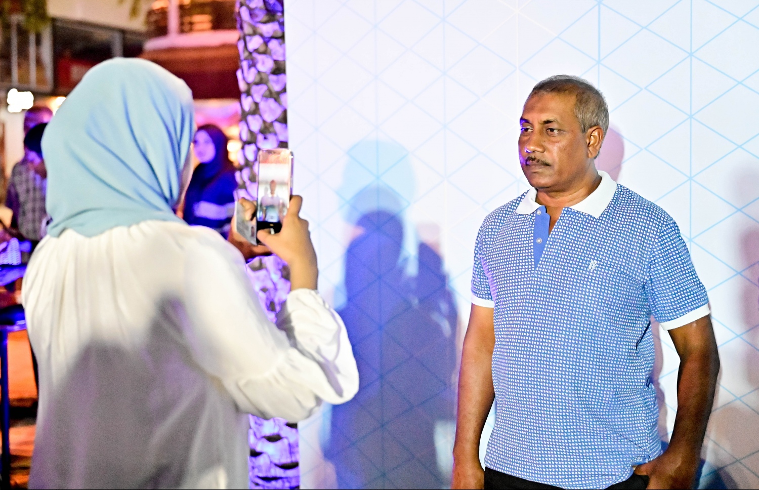 ކުރީގެ ރައީސް އަދި އެމްޑީޕީގެ ކުރީގެ ރައީސް މުހައްމަދު ނަޝީދު ދަ ޑިމޮކްރެޓްސް އަށް ސޮއިކުރައްވަން ބޭއްވި ޖަލްސާ އަށް ދިޔަ މީހަކު ފޮޓޯއެއް ނަގަނީ.--- ފޮޓޯ: ނިޝާން އަލީ / މިހާރު