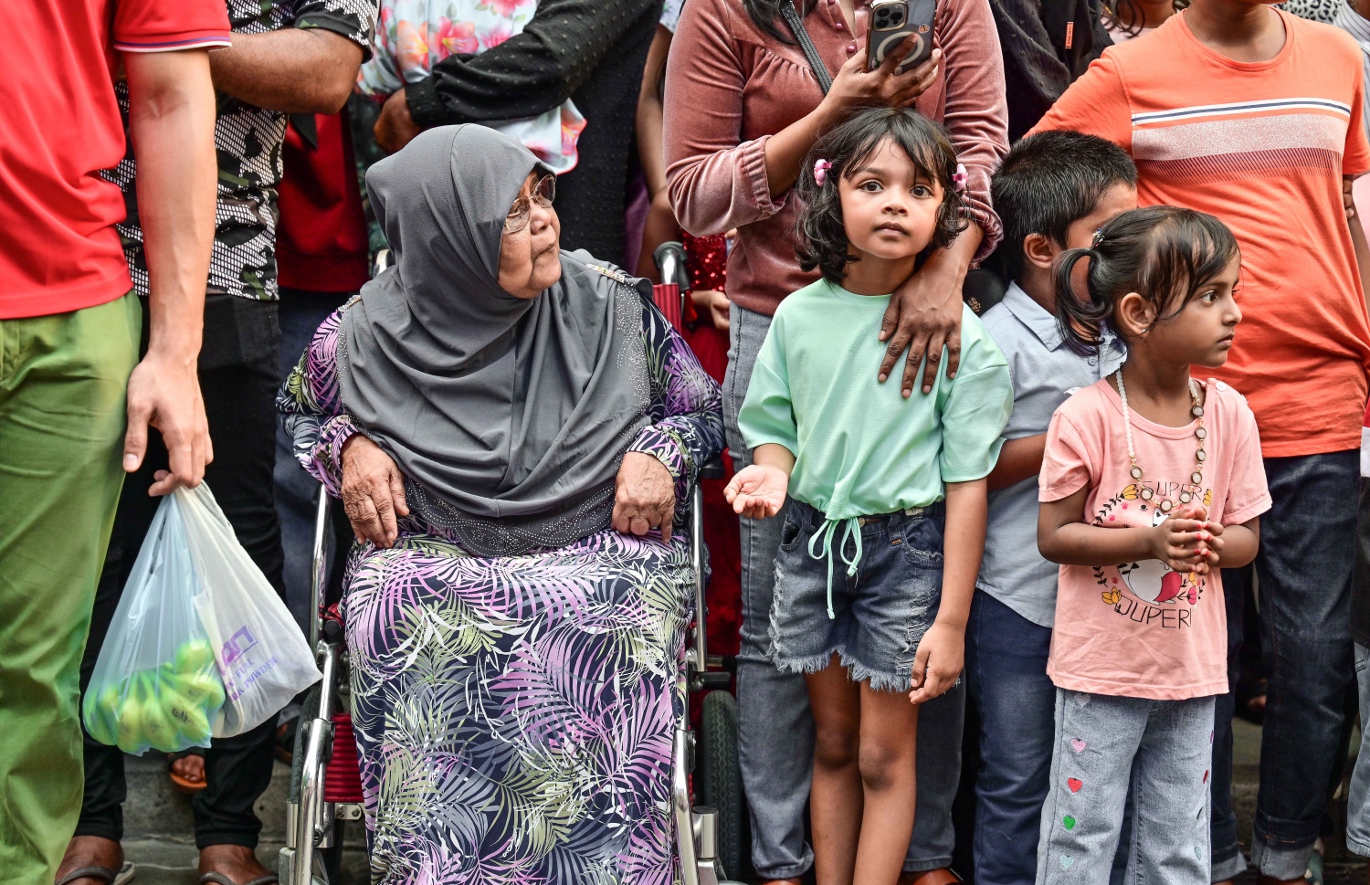 މިއަދު ބޭއްވި ޕެރޭޑް ބަލާލުމަށް އުމުރުން ދުވަސްވީ މީހަކު އޭނާގެ މާމަ ދަރިންނާއެކު މަޖީދީމަގުގައި -- ފޮޓޯ:ނިޝާން އަލީ | މިހާރު