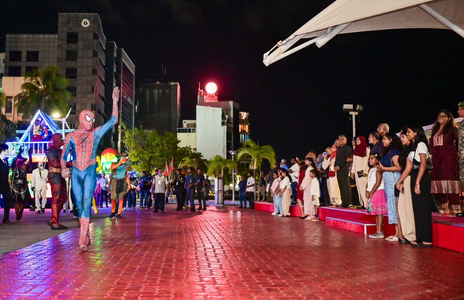 ފުޅަނދުބުރު ބައްލަވާލެއްވުމަށް ރައީސް އިބްރާހިމް މިހައްމަދު ސޯލިހް އިއްޒްުއްދީން ފާލަން ކުރިމަތީގައި މަޑުކޮއްލައިގެން. ފުޅަނދުބުރުގައި ބައިވެރިވި މީހަކު ސަރަފުވެރި މެހުމާނުންނަށް ހަނާ އަޅާލަނީ -- ފޮޓޯ: ފަޔާޒު މޫސާ | މިހާރު