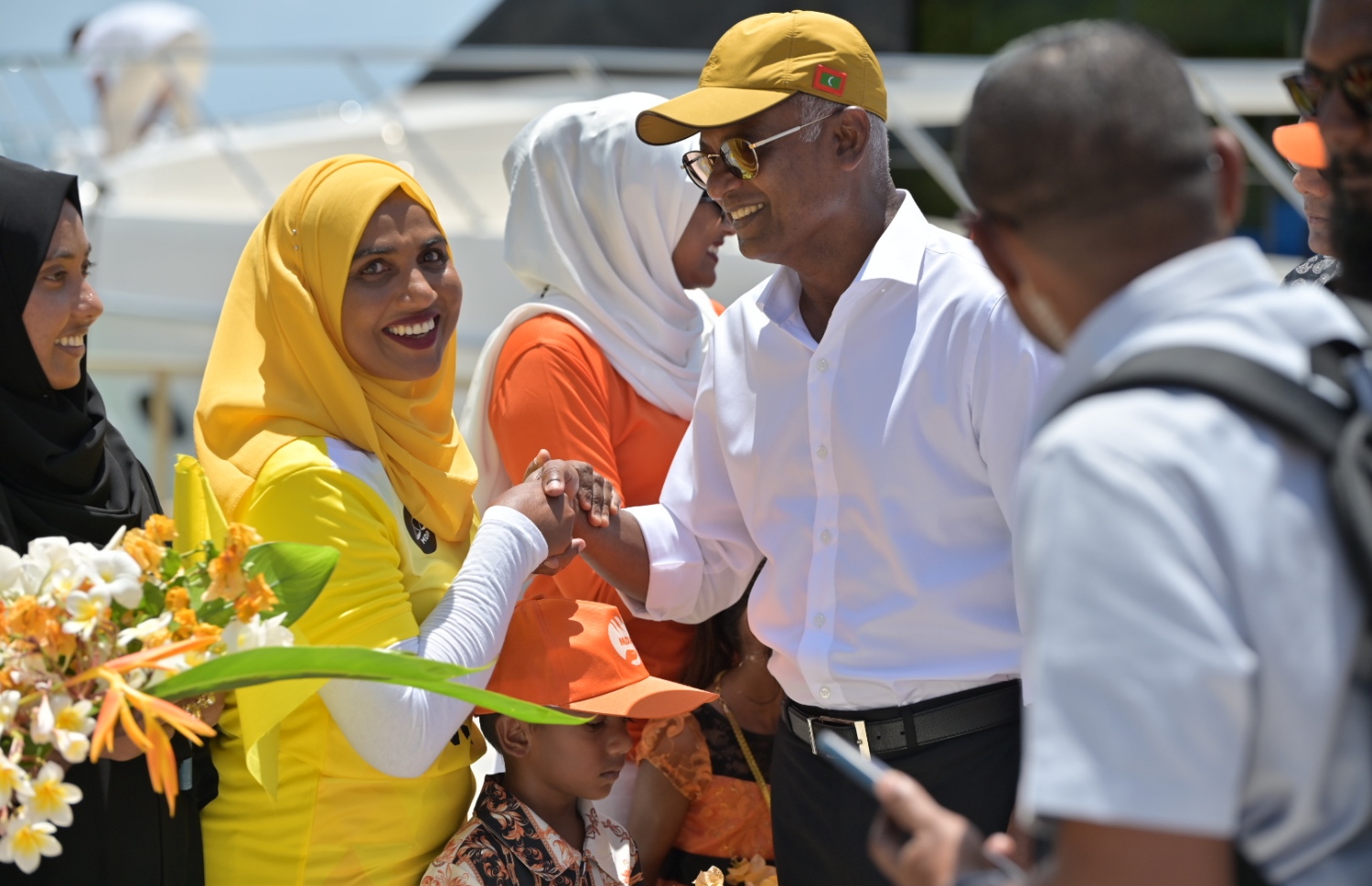 ކުޑަފަރިން ރައީސަށް މަރުހަބާ ދަންނަވަން ނުކުތް މީހަކާ ސަލާންކުރައްވަނީ. -- ފޮޓޯ | އެމްޑީޕީ