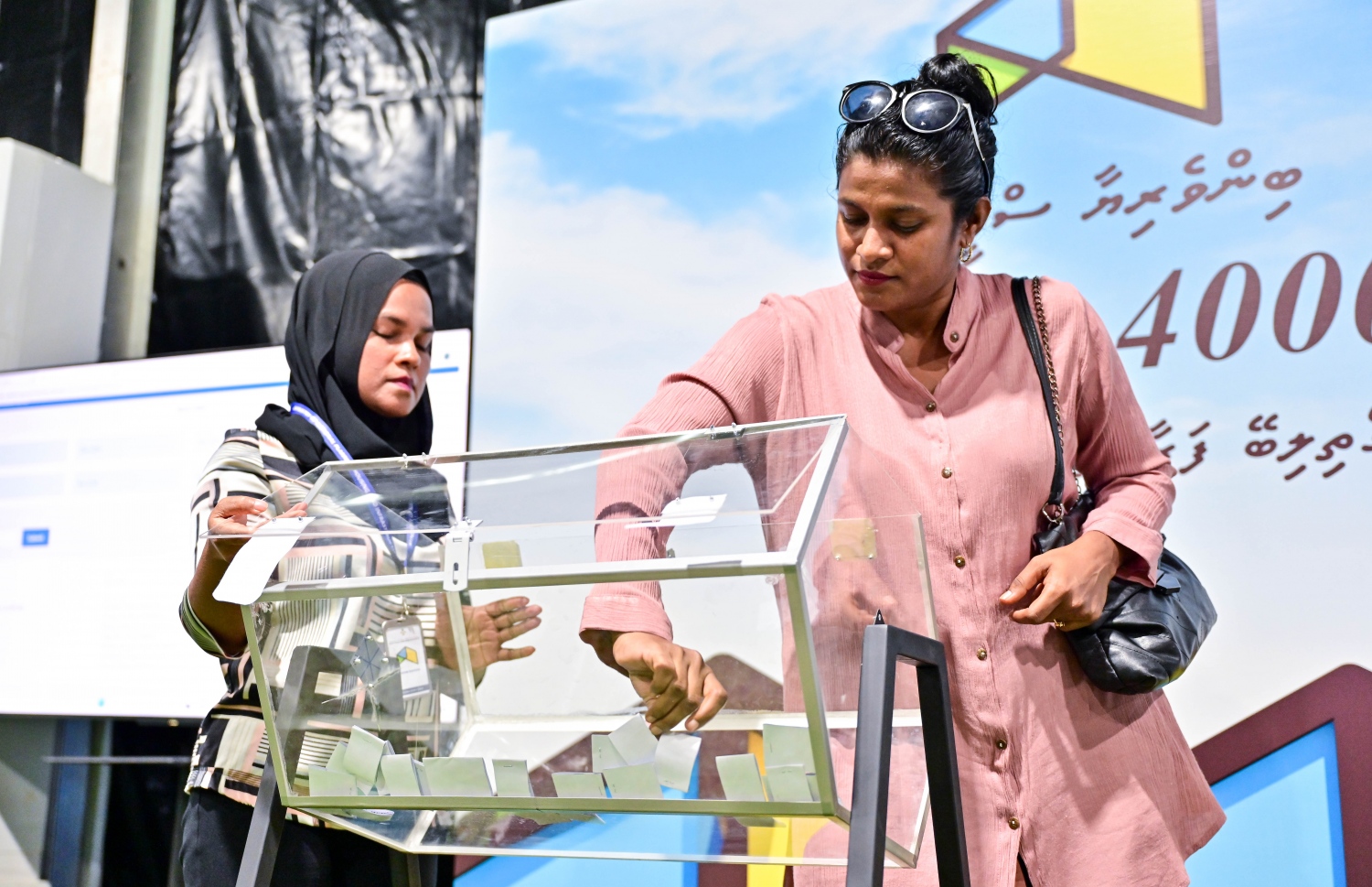 މާލެ ސަރަހައްދުން ދޫ ކުރާ ގޯތީގެ ގުރުގައި ބައިވެރިވި މީހަކު ޕޮލްޓް ނަންބަރު ޖަހާފައިވާ ކަރުދާސްކޮޅު ބަކެޓުން ނަގަނީ.-- ފޮޓޯތައް: ފަޔާޒް މޫސާ /މިހާރު