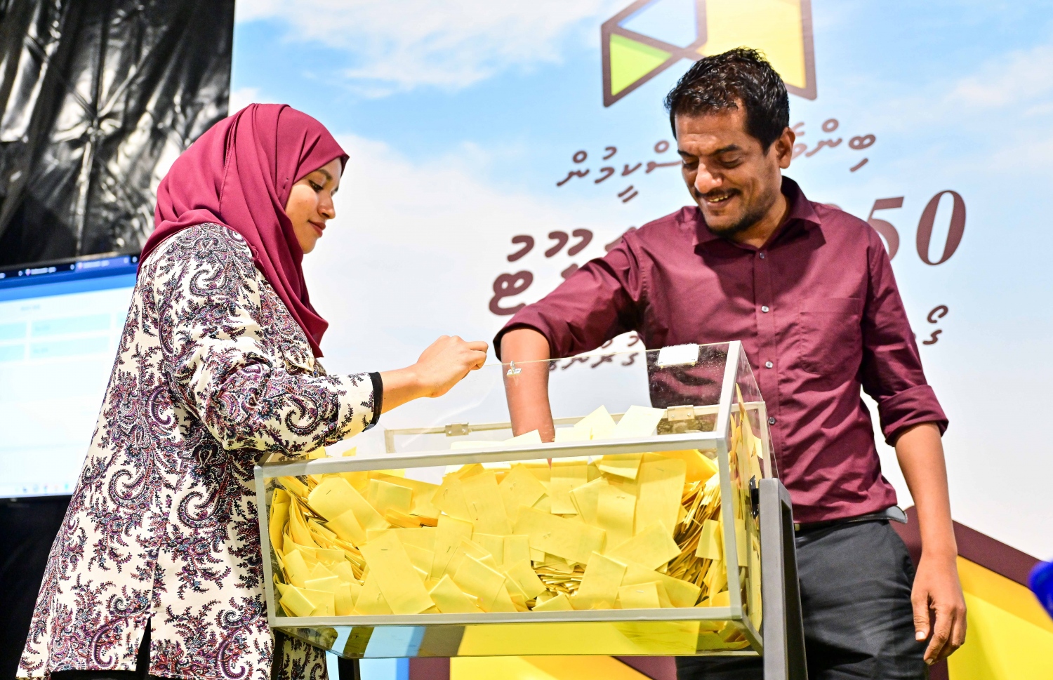 މާލެ ސަރަހައްދުން ދޫ ކުރާ ގޯތީގެ ގުރުގައި ބައިވެރިވި މީހަކު ޕޮލްޓް ނަންބަރު ޖަހާފައިވާ ކަރުދާސްކޮޅު ބަކެޓުން ނަގަނީ.-- ފޮޓޯތައް: ފަޔާޒް މޫސާ /މިހާރު