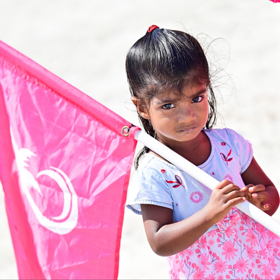 ޕީޕީއެމް/ޕީއެންސީގެ ރިޔާސީ ކެންޑިޑޭޓް ޑރ. މުހައްމަދު މުއިއްޒު ކެމްޕެއިނަށް ދ. މާއެނބޫދު އަށް ވަޑައިގަތުމުން މަރުހަބާ ކިޔަން ނުކުތް މީހުންނާ އެކު ދިޔަ ކުޑަކުއްޖަކު ޕީޕީއެމްގެ ދިދައެއް ހިފައިގެން.-- ފޮޓޯ: ނިޝާން އަލީ | މިހާރު