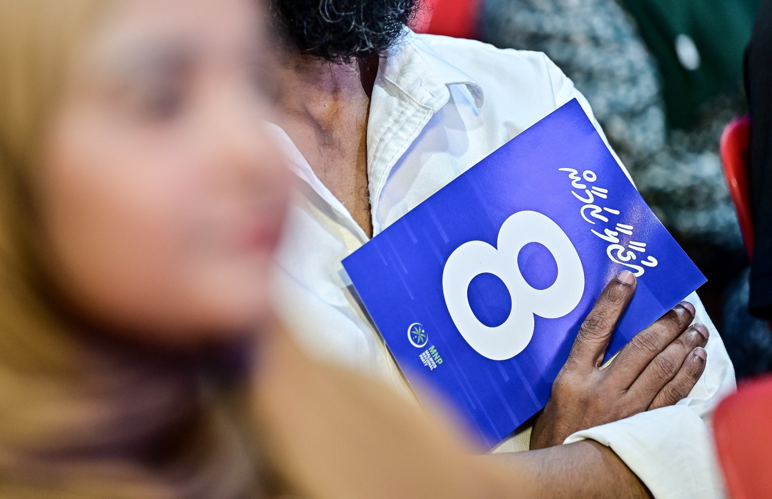 މާލެއާ މެދު ނާޒިމްގެ ސަރުކާރެއްގައި ގެންގުޅޭ ސިޔާސަތު ހާމަކުރަން މިރޭ ބޭއްވި ޖަލްސާގައި ބައިވެރިވި ސަޕޯޓަރަކު ނާޒިމްގެ ކެންޑިޑޭޓް ނަމްބަރު 8 ދައްކައިދޭ ކަރުދާސްގަނޑެއް ހިފައިގެން.--- ފޮޓޯ: ފަޔާޒު މޫސާ| މިހާރު