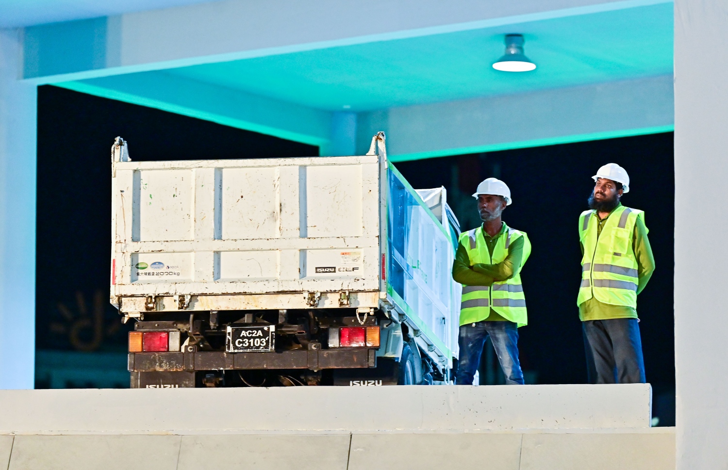 އަލަށް ހުޅުވި ވޭސްޓް ޓްރާންސްފާ ސްޓޭޝަންގައި ވެމްކޯގެ ދެ މުއައްޒަފަކު ކުނި ނަގާ ލޯރީ ކައިރީގަ މަޑުކޮއްލައިގެން -- ފޮޓޯ: ފަޔާޒު މޫސާ | މިހާރު