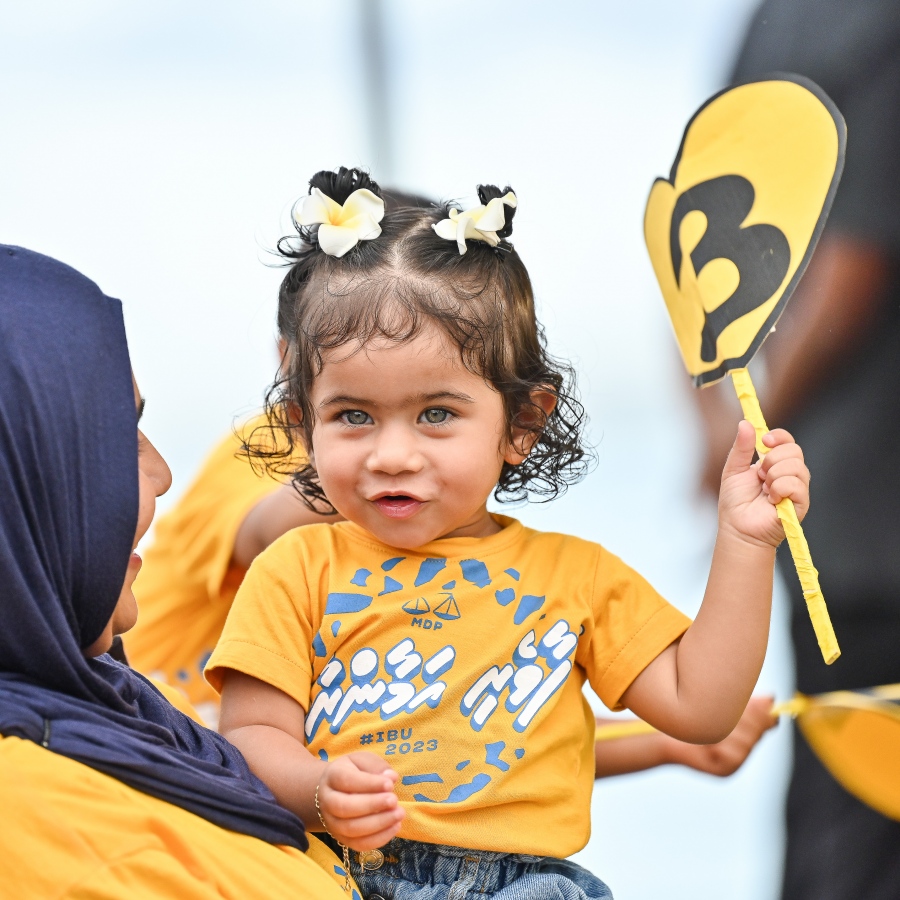 އެމްޑީޕީގެ ރިޔާސީ ކެންޑިޑޭޓް ރައީސް އިބްރާހިމް މުހައްމަދު ސޯލިހު ގދ. ތިނަދުއަށް ވަޑައިގަތުމުން އެމަނިކުފާނަށް މަރުހަބާ ކިޔުމަށް ނުކުތް މީހުން ސަފުގައި މީހަކު އުރައިގެން ހުރި ކުޑަކުއްޖެއް.-- ފޮޓޯ: ފަޔާޒް މޫސާ | މިހާރު