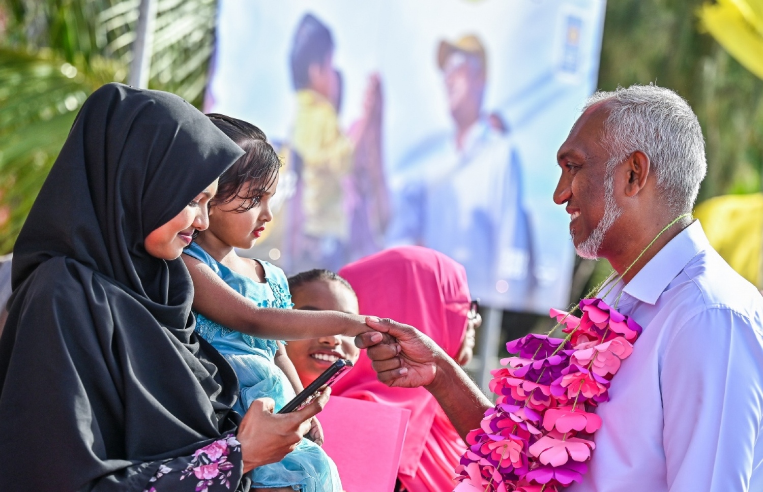 ޑރ. މުއިއްޒު ކެމްޕެއިނަށް ނ. ހޮޅުދު އަށް ވަޑައިގަތުމުން މަރުހަބާ ކިޔަން ދިޔަ މީހަކު އުރާލައިގެން ހުރި ކުޑަކުއްޖަކާ ސަލާން ކުރައްވަނީ.---ފޮޓޯ: ފަޔާޒު މޫސާ| މިހާރު