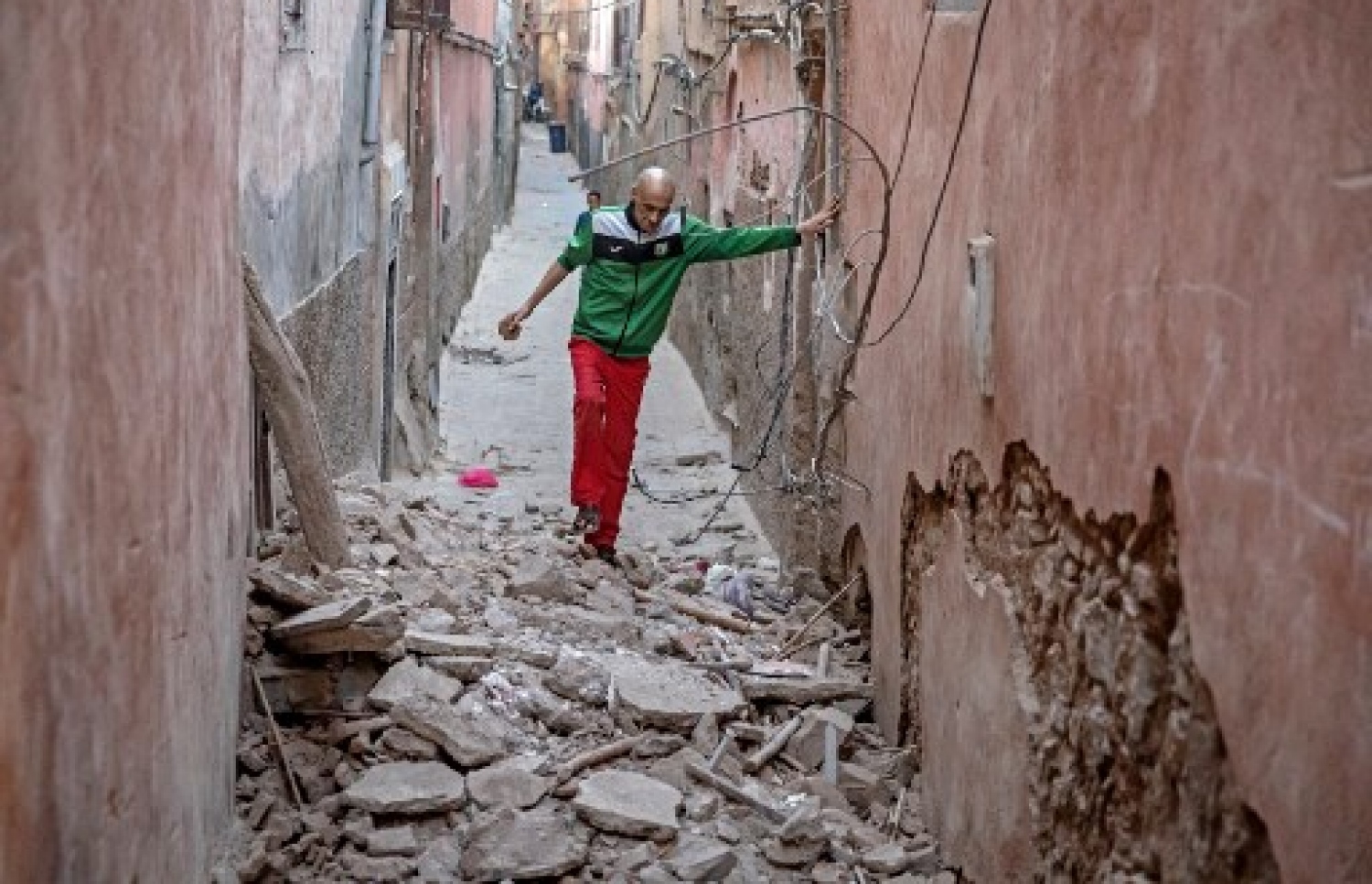 މޮރޮކޯގެ ބިންހެލުމުގައި ގެއްލުން ލިބުނު އިމާރާތެއްގެއްގައި މީހަކު ހިނގާފައި އަންނަނީ: ބާރުގަދަ އެ ބިންހެލުމުގައި 2000 އަށް ވުރެ ގިނަ މީހުން މަރުވި --- ފޮޓޯ: އޭއެފްޕީ