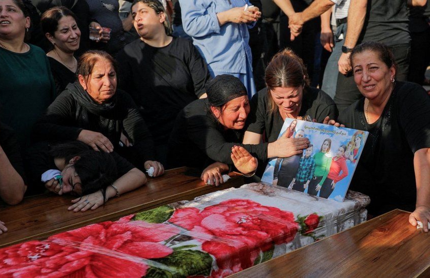 މަރުވި މީހުންގެ ޖަނާޒާގައި މީހެއްގެ ސަންދޯކެއް ކައިރީގައި އާއިލާގެ ބައެއް މީހުން ހިތާމަ ފާޅުކުރަނީ.