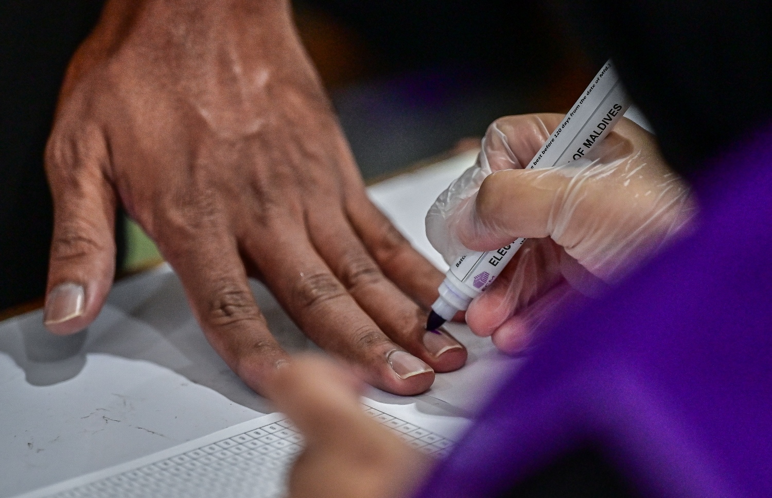 ރިޔާސީ އިންތިހާބުގެ ދެ ވަނަ ބުރުގައި ތާޖުއްދީން ސްކޫލުގައި ބަހައްޓާފައި ހުރި ވޯޓު ފޮއްޓަށް ވޯޓުލުމަށް މީހަކު އިނގިލީގައި ފާހަގަ ޖަހަނީ.-- ފޮޓޯ: ފަޔާޒް މޫސާ /މިހާރު