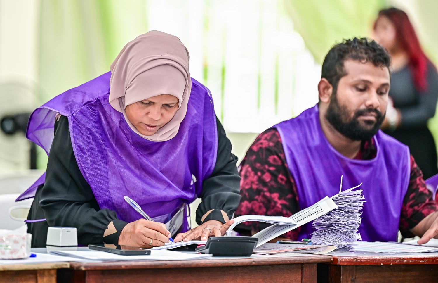 ރިޔާސީ އިންތިހާބުގެ ދެ ވަނަ ބުރުގައި އޮފިޝަލުން ވޯޓާސްލިސްޓް ޗެކްކުރަނީ.-- ފޮޓޯ: ފަޔާޒް މޫސާ /މިހާރު