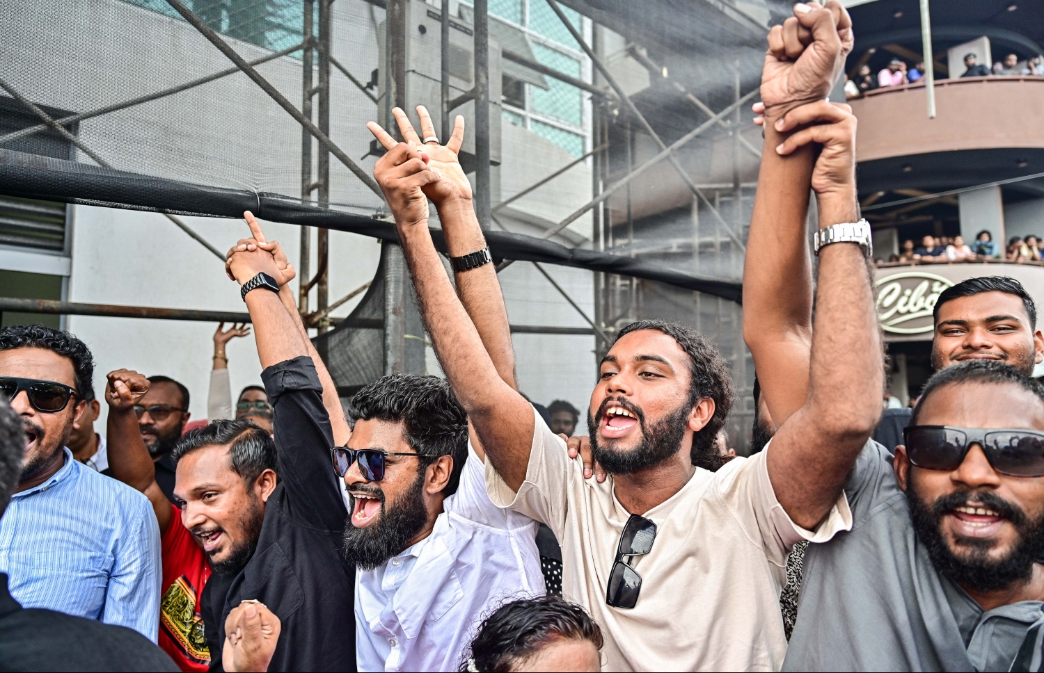 ކުރީގެ ރައީސް ޔާމީން ޖަލުން ގޭ ބަންދަށް ބަދަލުކުރުމުން ގެކޮޅަށް ވަޑައިގަންނަވާ ވަގުތެއްގެ އިންތިޒާރުގައި ސަޕޯޓަރުންތަކެއް އެއްވެ އުފާފާޅުކުރަނީ: ޔާމީނަށް މަރުހަބާ ކިޔަން އެތައް ސަތޭކަ ބަޔަކު އެ މަނިކުފާނުގެ ގެކޮޅު ކައިރި އަށް ޖަމާވި. ޔާމީނަށް އިސްވެ މަރުހަބާ ދެންނެވީ އިންތިހާބީ ރައީސް ޑރ. މުހައްމަދު މުއިއްޒު.---ފޮޓޯ: ނިޝާން އަލީ| މިހާރު