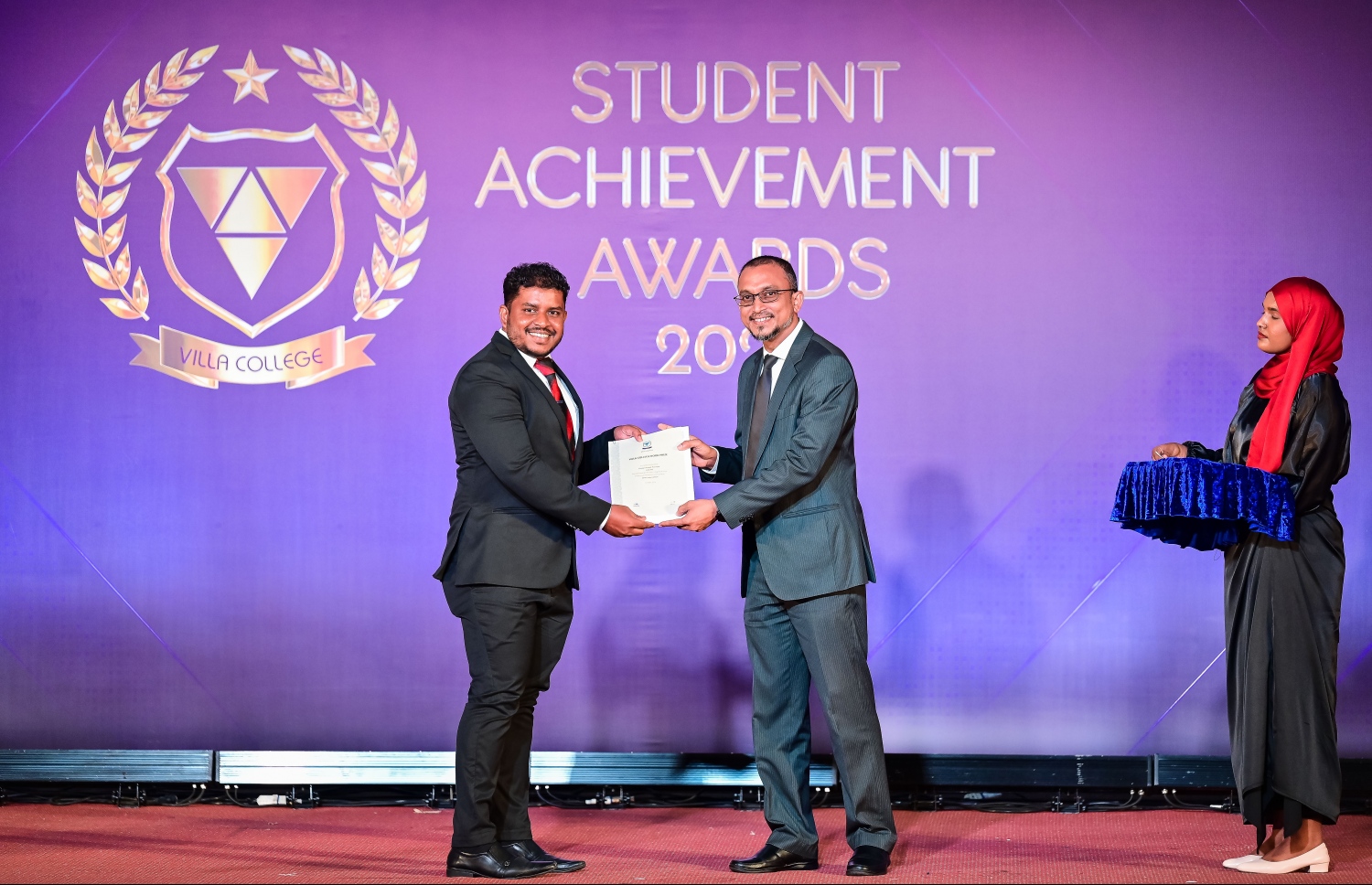 "ސްޓޫޑެންޓް އެޗީވްމަންޓް އެވޯޑްސް ނައިޓް"ގައި އެވޯޑު ހޯދި ދަރިވަރަކަށް އެވޯޑު ދެނީ. -- ފޮޓޯ: ނިޝާން އަލީ | މިހާރު