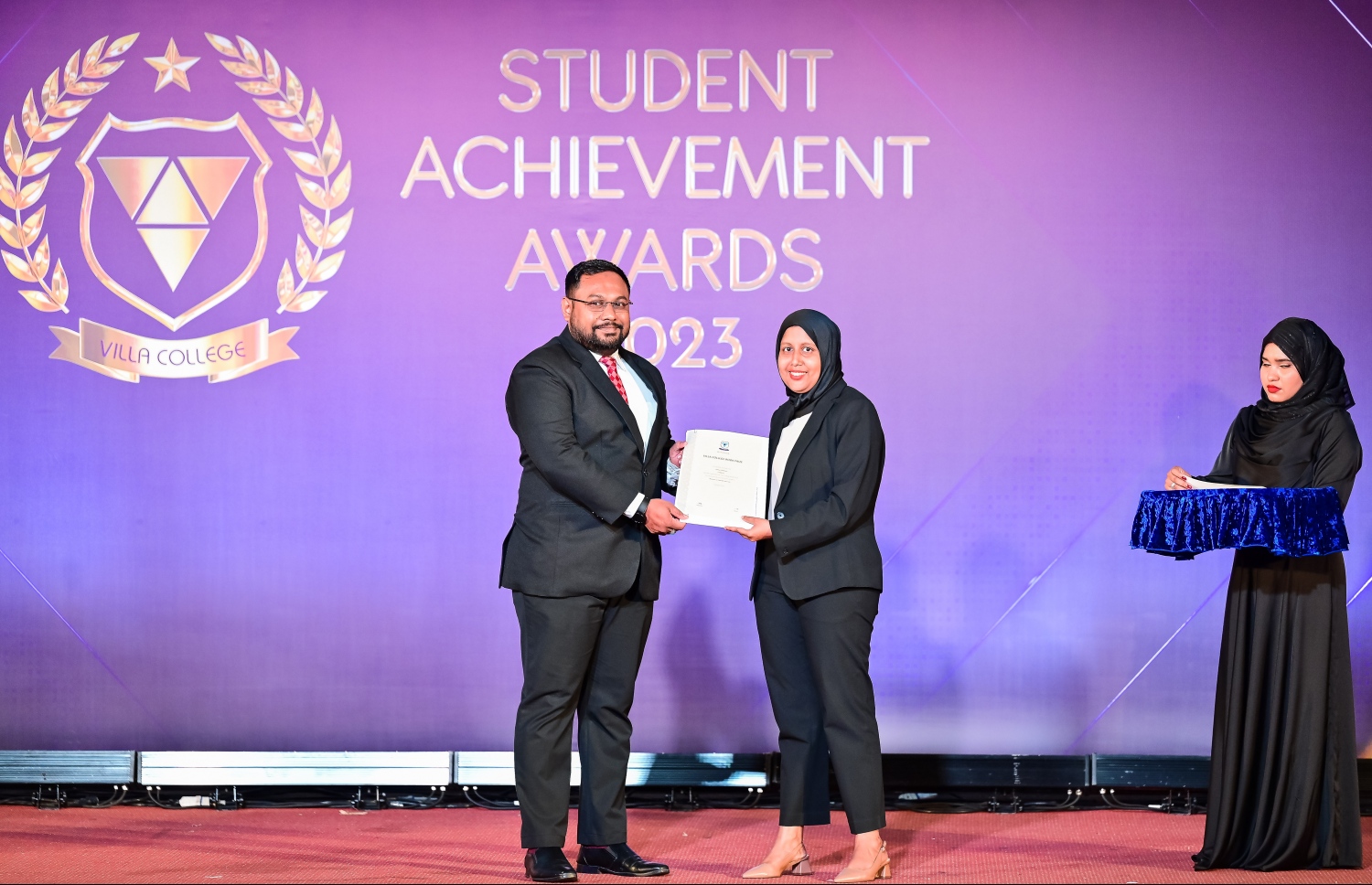 "ސްޓޫޑެންޓް އެޗީވްމަންޓް އެވޯޑްސް ނައިޓް"ގައި އެވޯޑު ހޯދި ދަރިވަރަކަށް އެވޯޑު ދެނީ. -- ފޮޓޯ: ނިޝާން އަލީ | މިހާރު