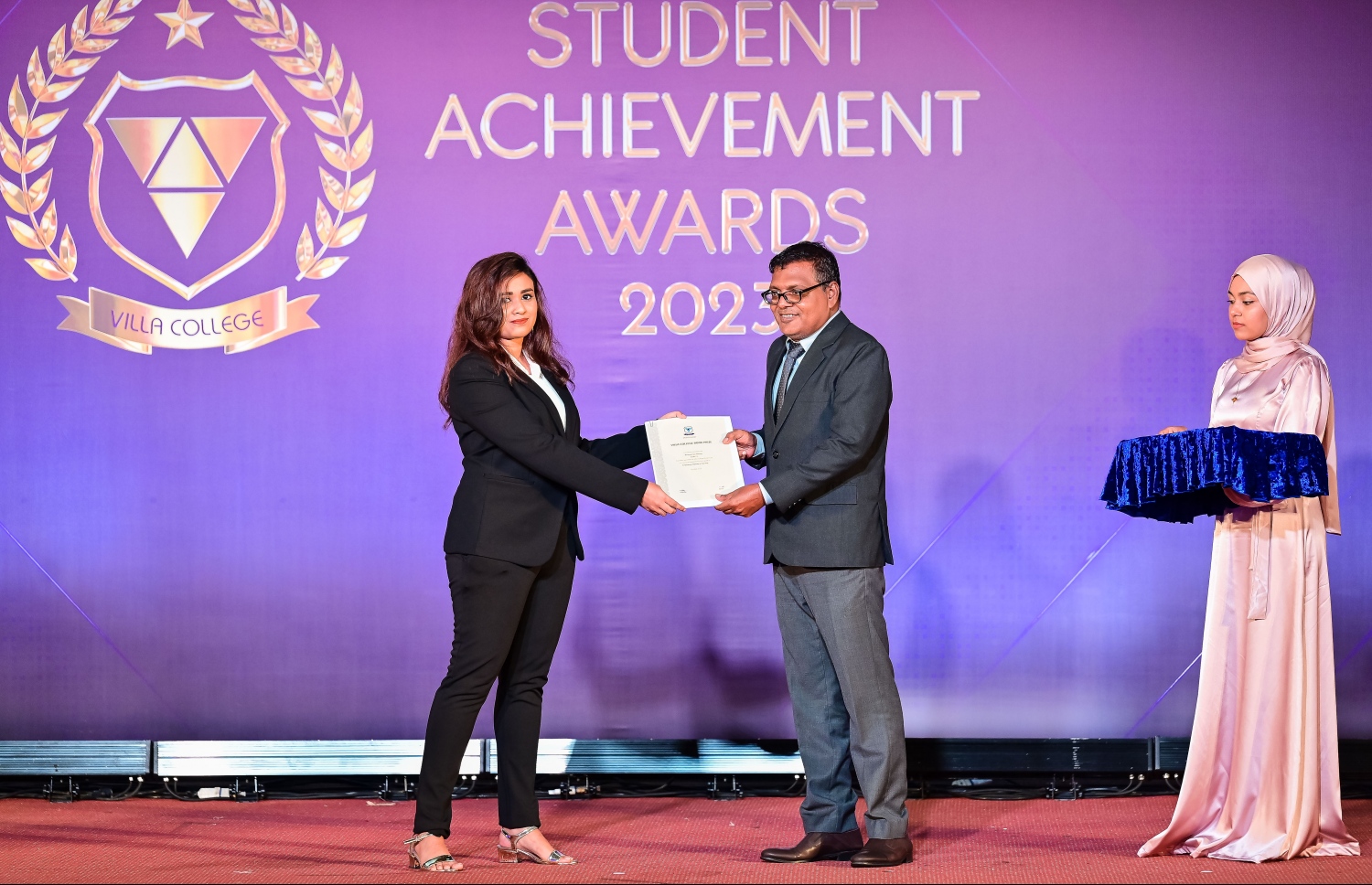 "ސްޓޫޑެންޓް އެޗީވްމަންޓް އެވޯޑްސް ނައިޓް"ގައި އެވޯޑު ހޯދި ދަރިވަރަކަށް އެވޯޑު ދެނީ. -- ފޮޓޯ: ނިޝާން އަލީ | މިހާރު