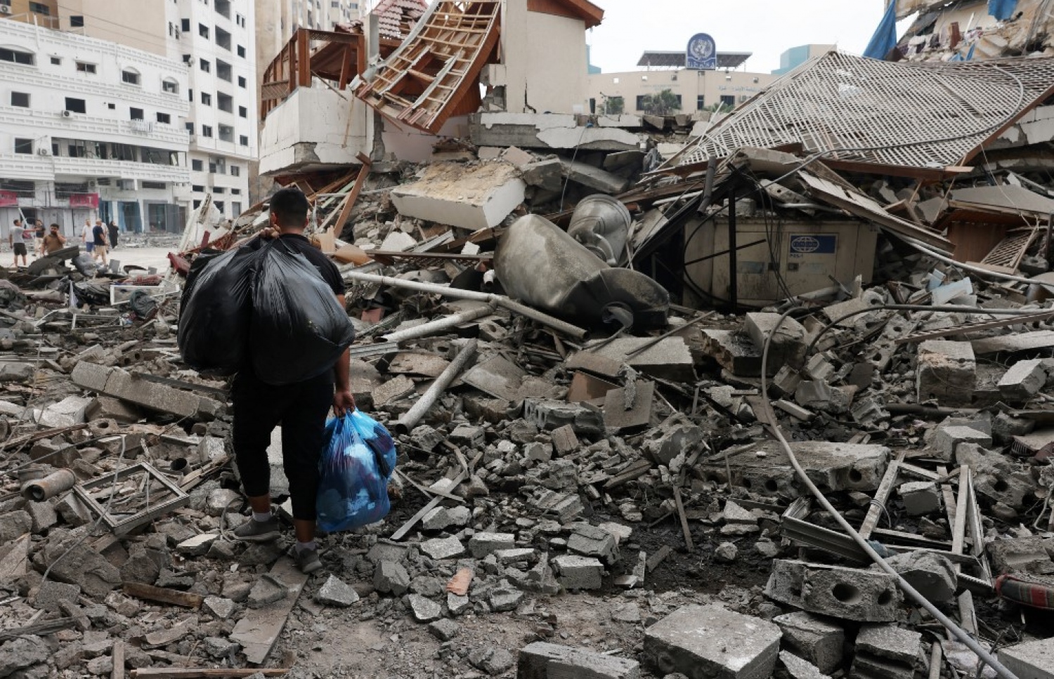 އިޒްރޭލުން ގާޒާ އަށް ދިން ވައިގެ ހަމަލާގައި ގެތަކެއް ބިމާ ހަމަވެފައިވާއިރު، ފަލަސްތީނުގެ ރައްޔިތަކު ކޮތަޅެއްގައި އެއްޗިހިތަކެއް ހިނގާފައި ދަނީ.-- ފޮޓޯ: އޭއެފްޕީ