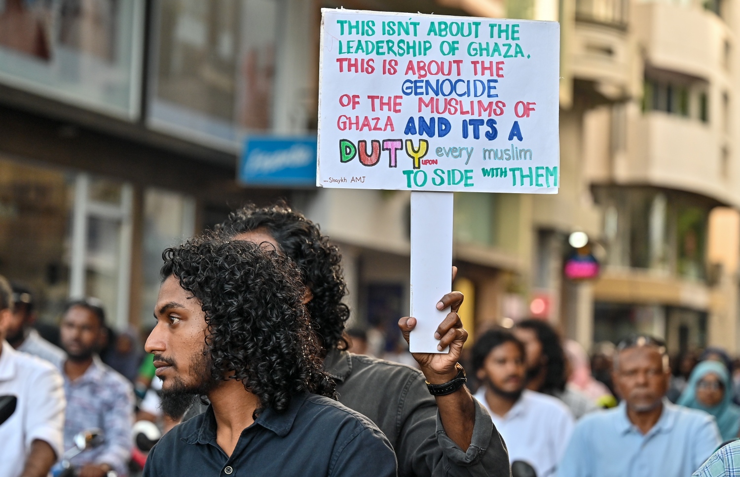 "ދިވެހިން ފަލަސްތީނާއެކު" ހަރަކާތުގެ ދަށުން މިއަދު ހަވީރު މާލޭގައި ކުރިއަށް ގެންދިޔަ ސައިކަލުބުރުގައި ޒުވާނެއްގެ ޝުއޫރުތައް ލިޔެފައިވާ ބޯޑެއް ހިފައިގެން -- ފޮޓޯ: ފަޔާޒު މޫސާ | މިހާރު