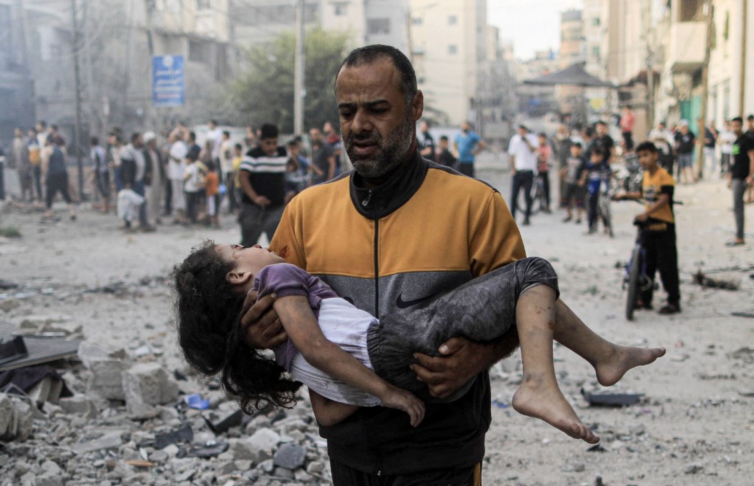 އިޒްރޭލުގެ ހަމަލާއެއްގައި ޒަހަމްވި ކުއްޖަކު ނަގައިގެން މީހަކު ގެންދަނީ.-- ފޮޓޯ: އޭއެފްޕީ