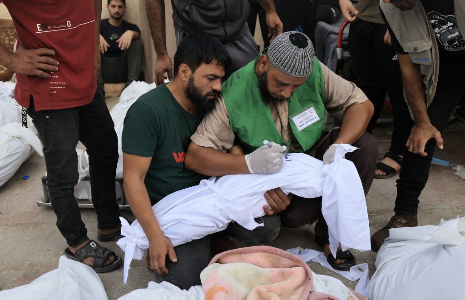 އިޒްރޭލުން ދިން ވައިގެ ހަމަލާއެއްގައި ނިޔާވި ތުއްތު ކުއްޖެއްގެ ނަން ހަށިގަނޑުގައި ބަނދެފައި އޮތް ފޮތިގަނޑުގައި ލިޔަނީ.-- ފޮޓޯ: އޭއެފްޕީ