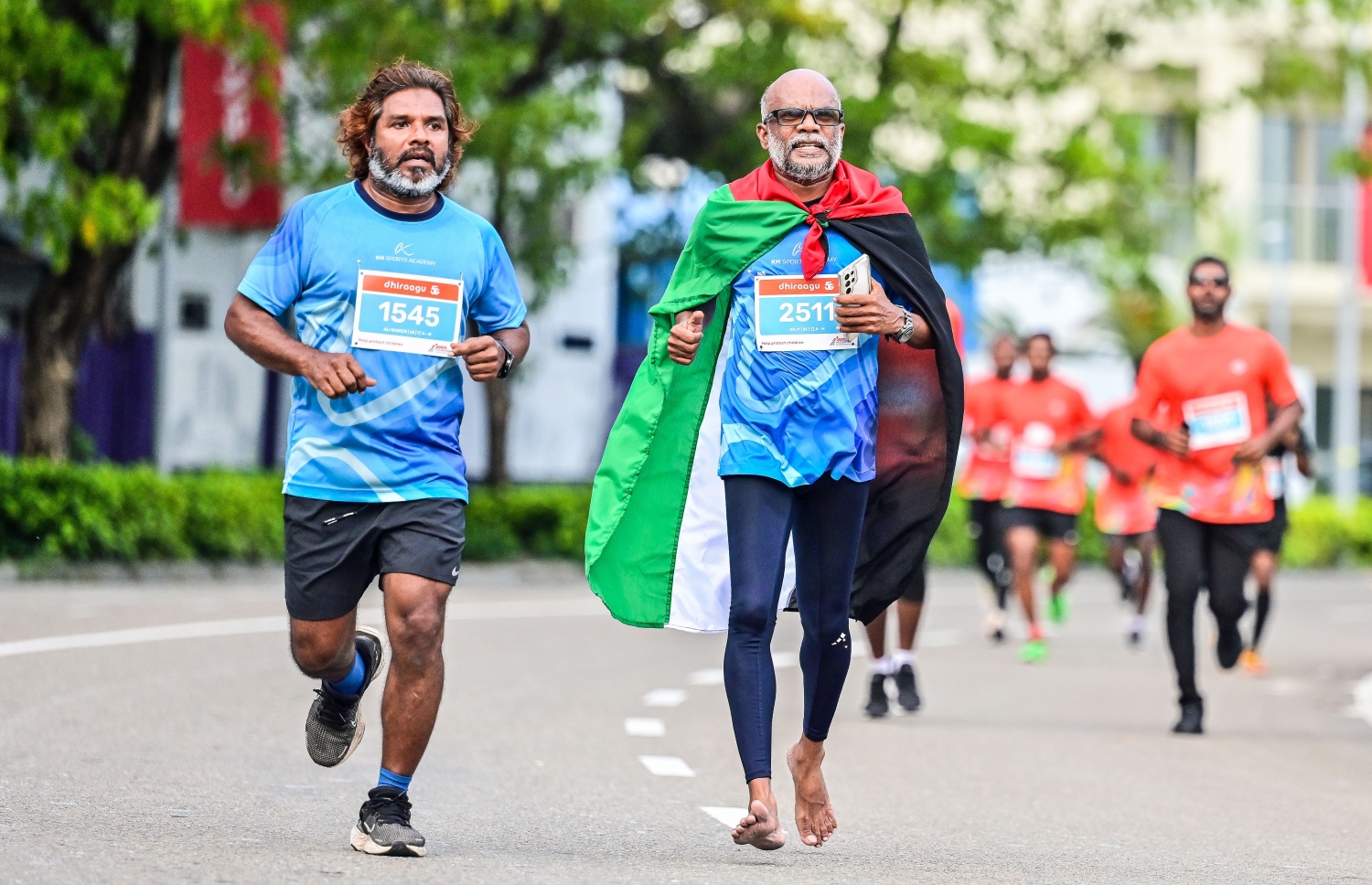 ކުރީގެ މަޝްހޫރު އެތުލީޓް ހުސެއިން ހަލީމް (ކުޑަ ހުސެއިން) ދިރާގު މޯލްޑިވްސް ރޯޑް ރޭހުގައި ފަލަސްތީން ދިދަ ހިފައިގެން ދުވަނީ -- ފޮޓޯ: ފަޔާޒު މޫސާ | މިހާރު