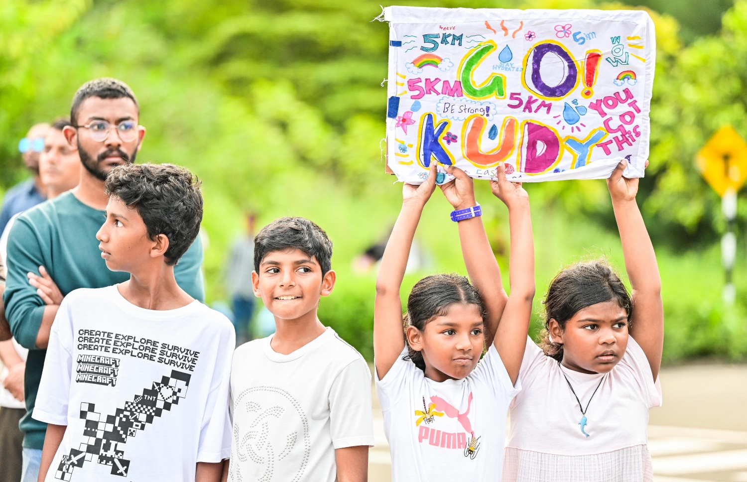 ދިރާގު މޯލްޑިވްސް ރޯޑް ރޭހުގެ ދުވުންތެރިޔަކަށް ތަރުހީބު ދިނުމުގެ ގޮތުން ކުޑަ ދެ ކުދިން ޕޯސްޓަރެއް ހިފައިގެން -- ފޮޓޯ: ފަޔާޒު މޫސާ | މިހާރު