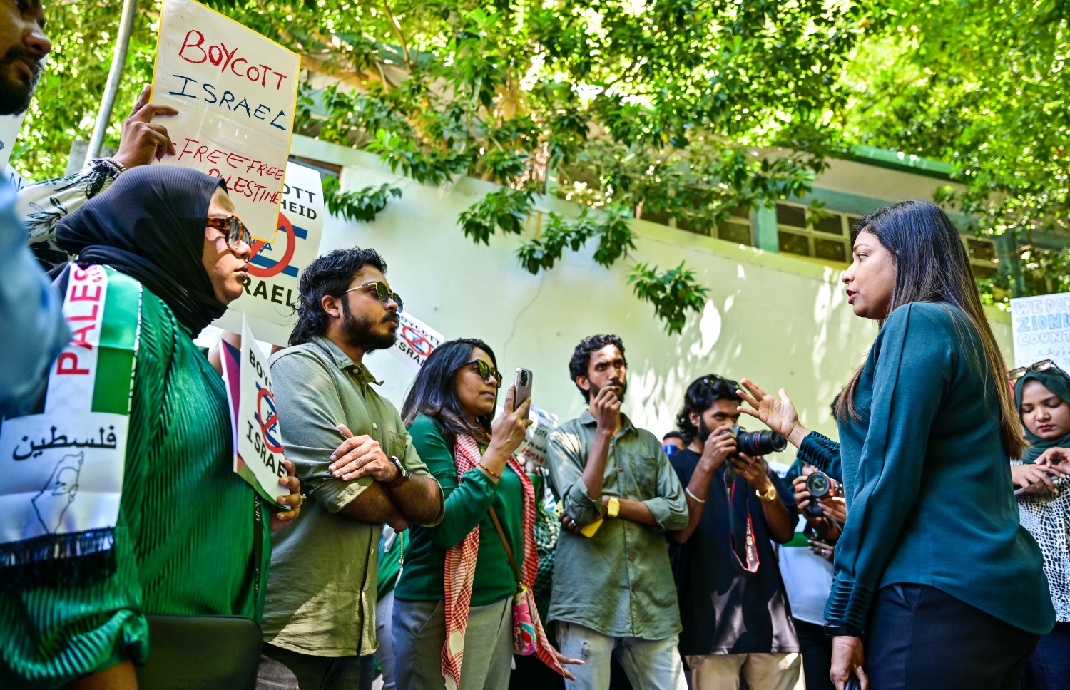 އިޒްރޭލުން ފަލަސްތީނުގެ މީހުންނާ ދެކޮޅަށް ހިންގާ ލާއިންސާނީ އަމަލުތައް ކުށްވެރިކޮށް، އެ ގައުމުގެ ޕާސްޕޯޓްގައި ރާއްޖެ އަށް ނާދެވޭ ގޮތް ހެދުމަށް ގޮވާލައި ޕްރެޝަރު ކުރުމަށް މިއަދު ރައްޔިތުންގެ މަޖިލީހުގެ އިދާރާ ކުރިމަތީ ބޭއްވި އިހުތިޖާޖުގައި ބައިވެރިން މީދޫ ދާއިރާގެ މެމްބަރު ރޮޒައިނާ އާދަމާ ސުވާލު ކުރަނީ.--- ފޮޓޯ: ފަޔާޒު މޫސާ / މިހާރު