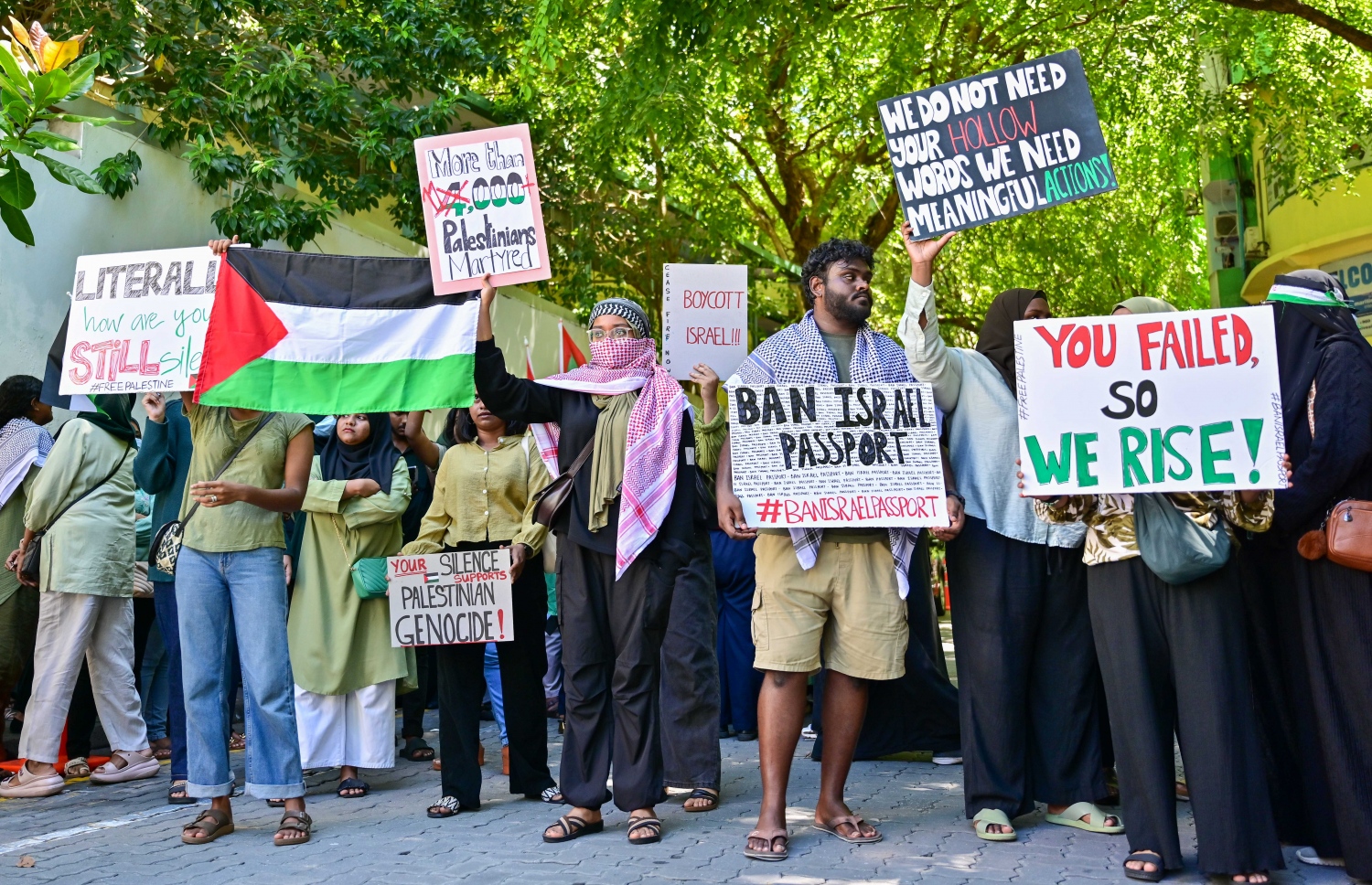 އިޒްރޭލުން ފަލަސްތީނުގެ މީހުންނާ ދެކޮޅަށް ހިންގާ ލާއިންސާނީ އަމަލުތައް ކުށްވެރިކޮށް، އެ ގައުމުގެ ޕާސްޕޯޓްގައި ރާއްޖެ އަށް ނާދެވޭ ގޮތް ހެދުމަށް ގޮވާލައި ޕްރެޝަރު ކުރުމަށް މިއަދު ރައްޔިތުންގެ މަޖިލީހުގެ އިދާރާ ކުރިމަތީ ބޭއްވި އިހުތިޖާޖުގެ ބައެއް ބައިވެރިން.--- ފޮޓޯ: ފަޔާޒު މޫސާ / މިހާރު