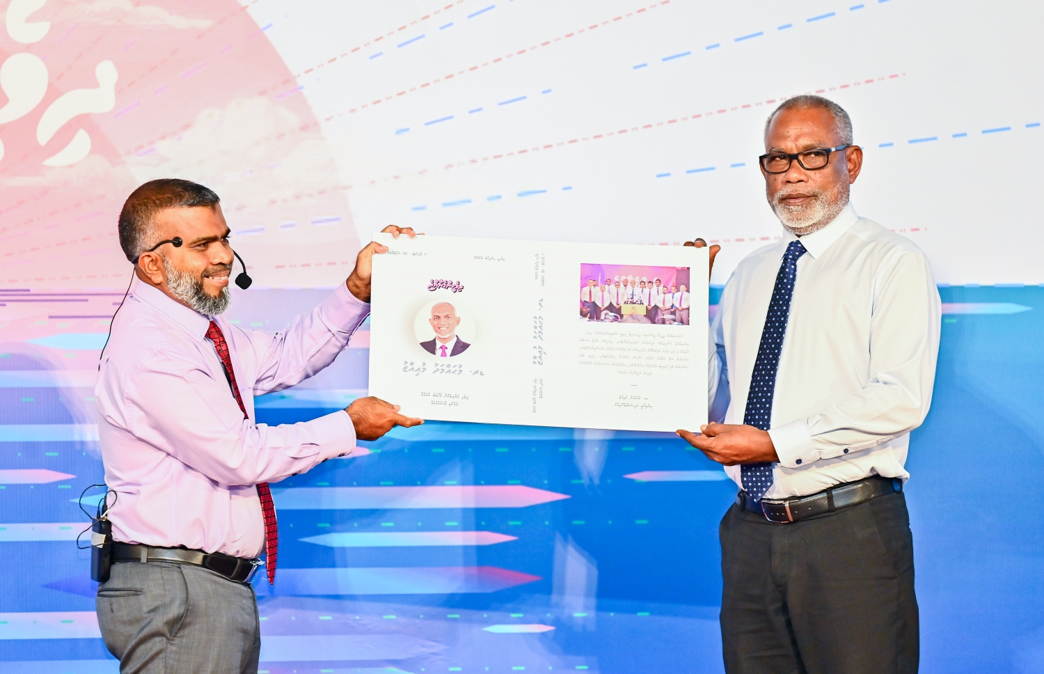 އިންތިހާބީ ރައީސް ޑރ. މުއިއްޒު ކެމްޕެއިންގައި ދެއްކެވި ވާހަކަފުޅުތައް ހިމެނޭ ފޮތް ޑިރެކްޓަ ޖެނެރަލް އޮފް ޓްރާންސިޝަން އަބްދުއްރަހީމް ނެރެދެއްވާއިރު އޭނާއާ އެކު އިކްރާމް.---ފޮޓޯ: ފަޔާޒު މޫސާ | މިހާރު