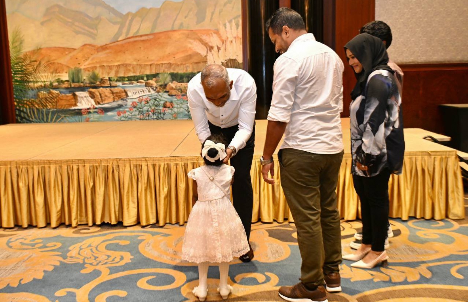 ދުބާއީގައި ދިރިއުޅޭ ދިވެހިންނާ އެކު ރައީސް ޑރ. މުއިއްޒު ރޭ ބޭއްވެވި ބައްދަލުވުމުގައި ކުޑަކުއްޖެއްގެ ކޮލުގައި ފިރުމާލައްވަނީ.---ފޮޓޯ: ރައީސް އޮފީސް