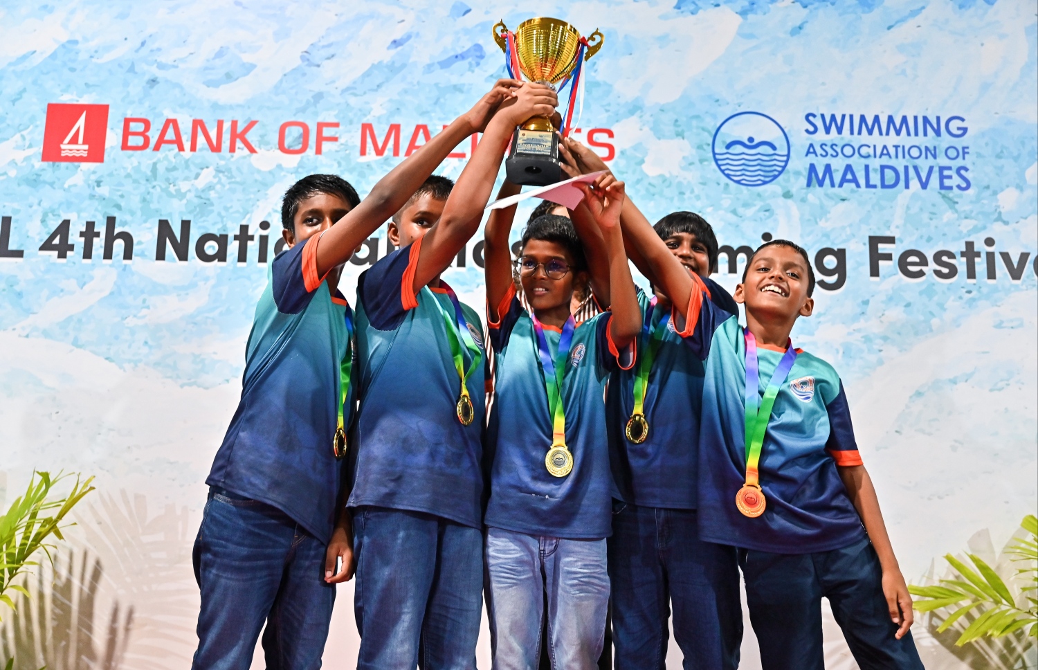 ބީއެމްއެލް ނެޝެނަލް ކިޑްސް ސުވިމިން ފެސްޓިވަލް ނިންމުމުގެ ރަސްމިއްޔާތުގައި، އެ ފެސްޓިވަލުން ވަނަ ހޯދި ފިރިހެން ފެތުންތެރިން ތަށި އުފުލާލަނީ.--- ފޮޓޯ: ފަޔާޒު މޫސާ | މިހާރު