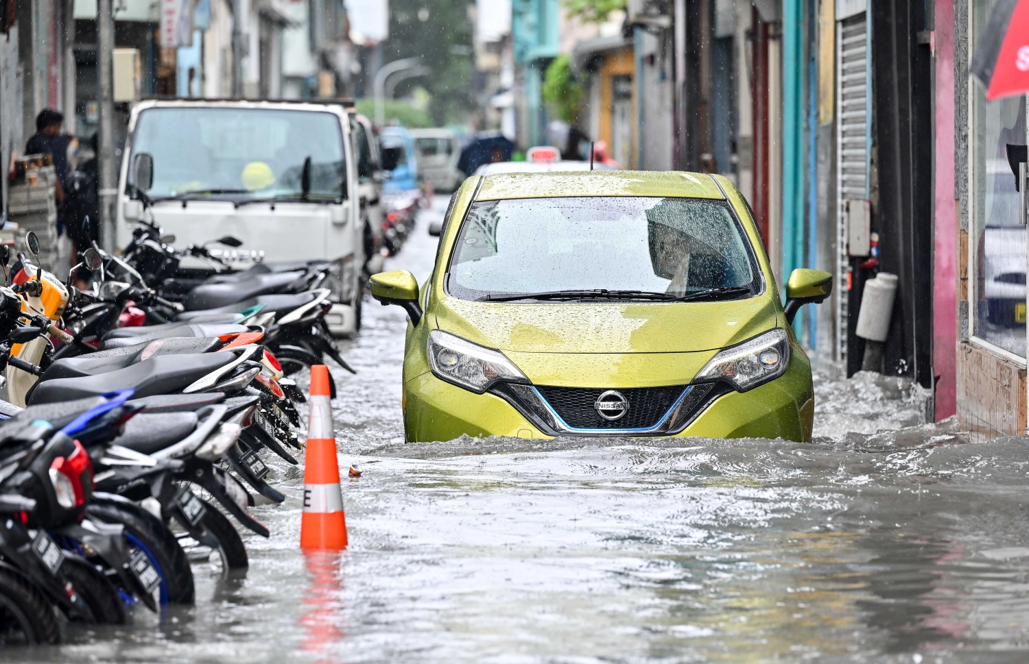 މާލެ އަށް ރެއިން ފެށިގެން ވެހެމުންދާ ބޯ ވާރޭގައި ފެން ބޮޑުވެފައިވާ މަގެއްގައި ކާރެއް ދުއްވާފައި.-- ފޮޓޯ: ނިޝާން އަލީ | މިހާރު