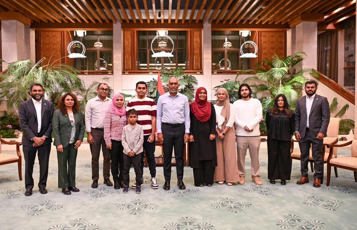 ރައީސް ޗައިނާއަށް ކުރެއްވި ރަސްމީ ދަތުރުފުޅުގައި، އެ ގައުމުގައި ކިޔަވާ ދަރިވަރުންގެ އާއިލާތަކާއެކު ރައީސް މުއިއްޒުގެ ދެކަނބަލުން ފޮޓޯއެއް ނަންގަވަނީ. -- ފޮޓޯ: ރައީސް އޮފީސް