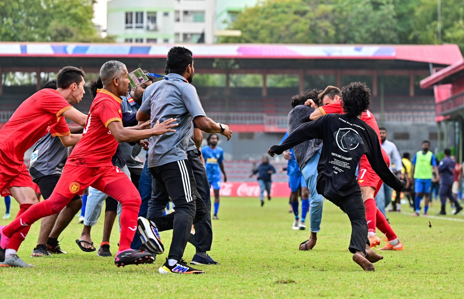 ވިކްޓަރީގެ އެނަޓޮލީ އަށް ސަޕޯޓަރުންތަކެއް ހަމަލާދޭއިރު ސޮބާ އާއި ޓީމުގެ އެހެން ބައެއް ކުޅުންތެރިން އޭނާ ހިމާޔަތް ކުރަން މަސައްކަތް ކުރަނީ.-- ފޮޓޯ: މިހާރު