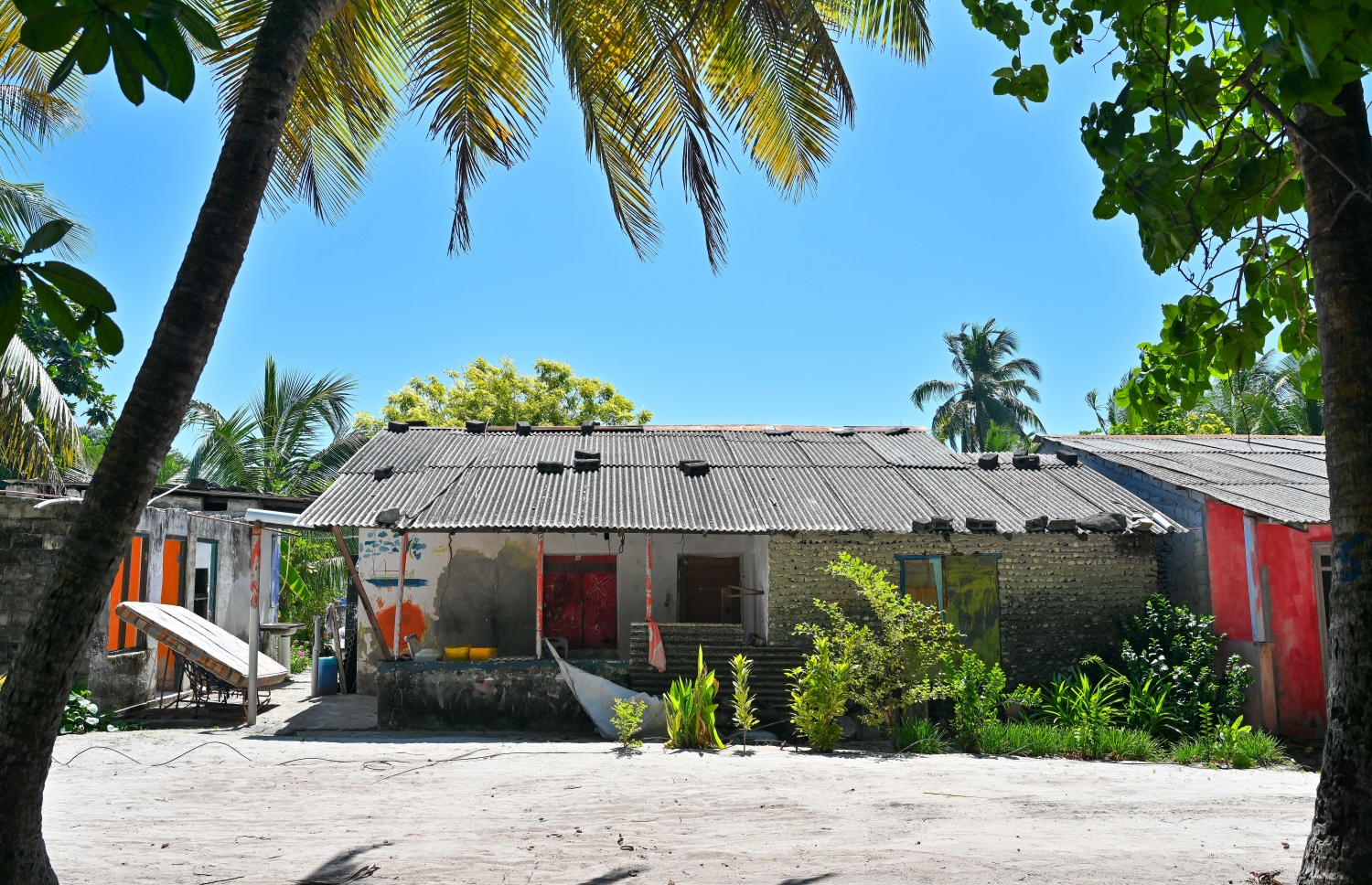 ނޫމަރާގައި މީހުން ދިރިއުޅޭ ގެއެއްގެ ބޭރުގައި ގޮދަޑިއަކާއި ބައެއް އެހެނިހެން އެއްޗެހި ހިއްކަން އަޅައިފަ ވާއިރު، އަދިވެސް ގިނަ މީހުން ދިރިއުޅެނީ އެންމެ އިހު ޒަމާނުގައި އިމާރަތްކޮއްފައި ހުރި ގެތަކުގައި -- ފޮޓޯ: ފަޔާޒު މޫސާ | މިހާރު