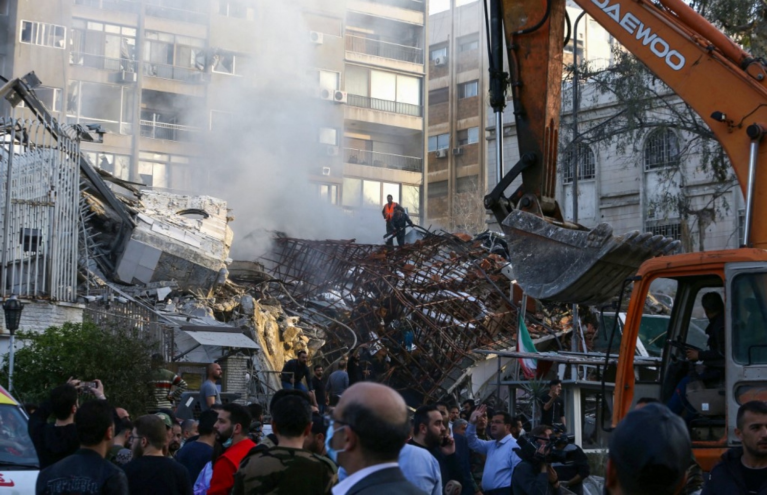 ސީރިއާގައި ހުންނަ އީރާން ކޮންސިއުލޭޓްގެ އިމާރާތަކަށް ހަމަލާދީ ބިމާ ހަމަކޮށްލާފައި ވާއިރު އެތަނުގެ ދަށުގައި ތާށިވެފައިވާ މީހުން ހޯދުމުގެ މަސައްކަތްކުރަނީ.  -- ފޮޓޯ: އޭއެފްޕީ