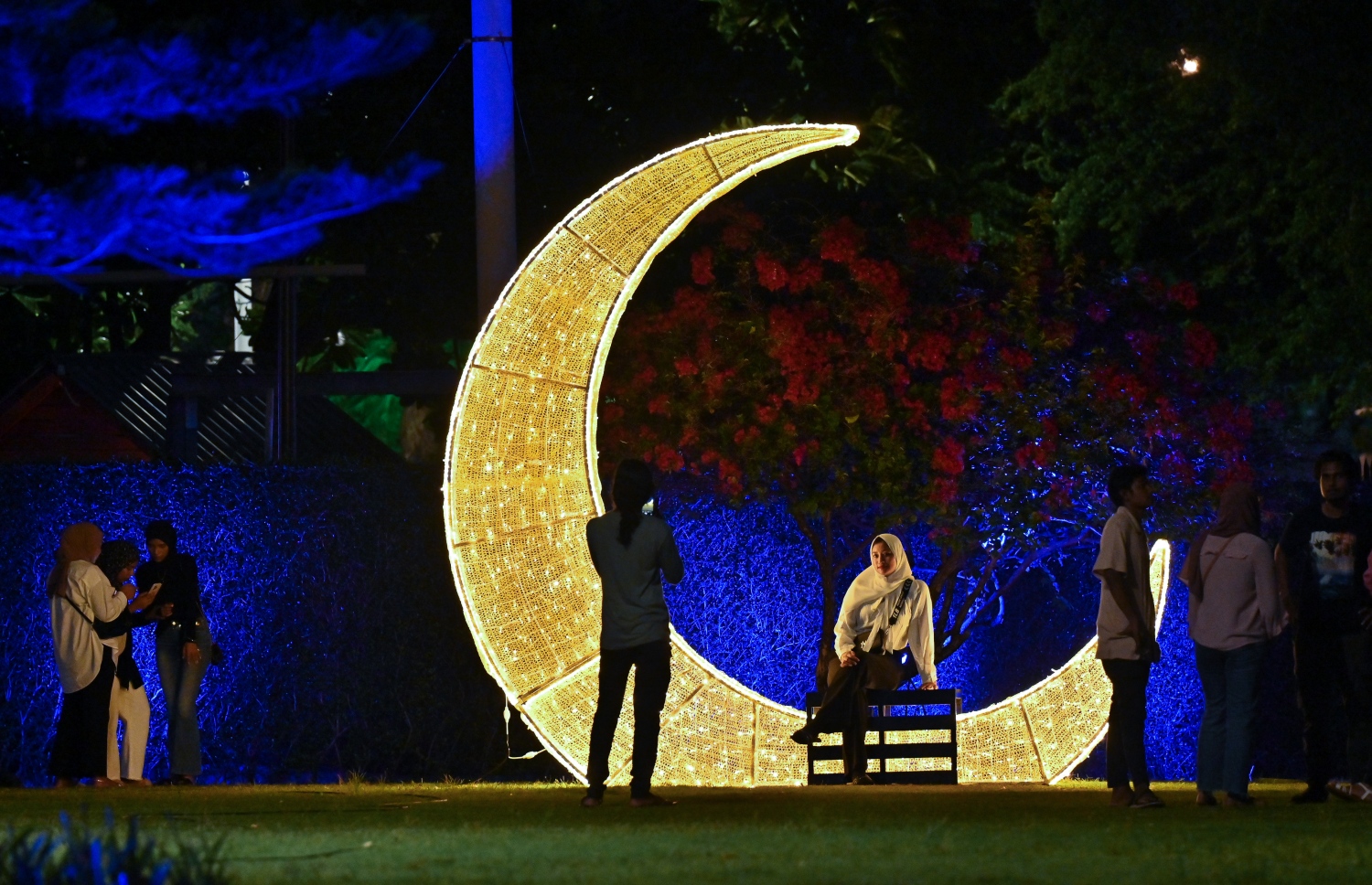 ފިތުރު އީދަށް ހުޅުމާލޭގެ އެކި ސަރަހައްދުތައް ކުލަ ބޮކިތަކާއި ޑިޒައިންތަކުން ޒީނަތްތެރިކޮށްފައި އޮތް އިރު، ދިއްލޭ ހަނދުފަޅިއެއްގައި އިނދެ މީހަކު ފޮޓޯ ނަގަނީ. -- ފޮޓޯ: ނިޝާން އަލީ | މިހާރު