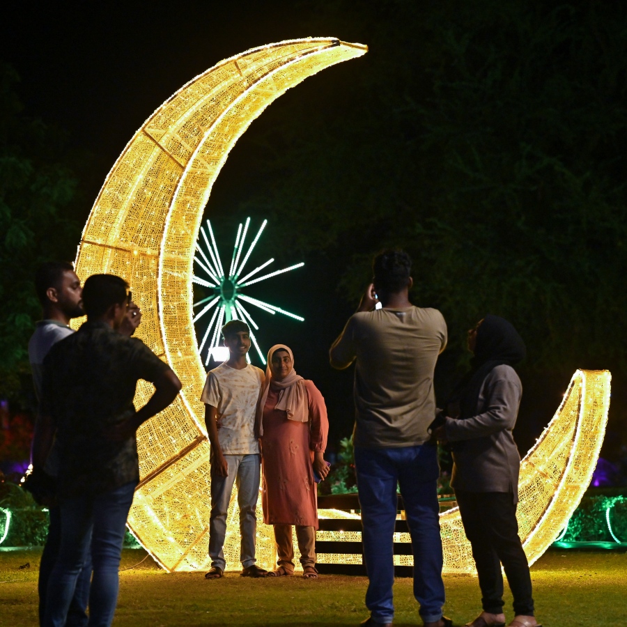 ފިތުރު އީދަށް ހުޅުމާލޭގެ އެކި ސަރަހައްދުތައް ކުލަ ބޮކިތަކާއި ޑިޒައިންތަކުން ޒީނަތްތެރިކޮށްފައި ވާއިރު ހުޅުމާލެ ސެންޓްރަލް ޕާކްގައި ދިއްލާފައިވާ ހަނދުފަޅިއެއް ގޮތަށް ހުރި ތަނެއްގެ ކައިރީ ބަޔަކު ފޮޓޯ ނަގަނީ. -- ފޮޓޯ: ނިޝާން އަލީ | މިހާރު