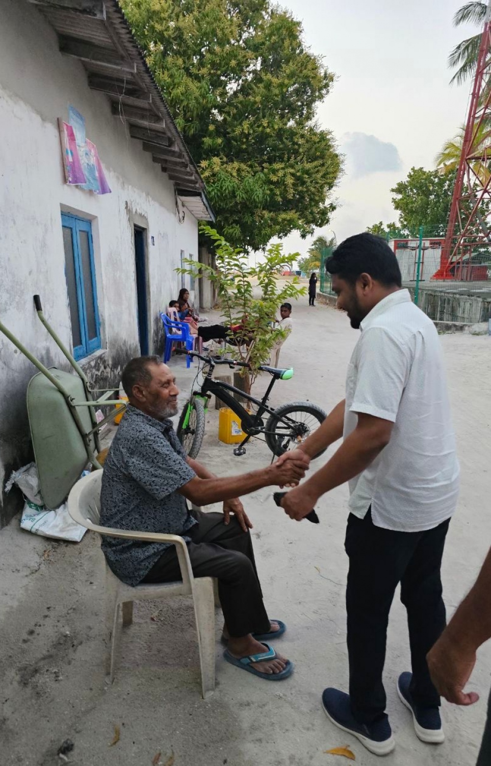 އަލީ ޒާހިރު، މަޖިލިސް ކެމްޕެއިންގައި މީހަކާ ސަލާން ކުރައްވަނީ.