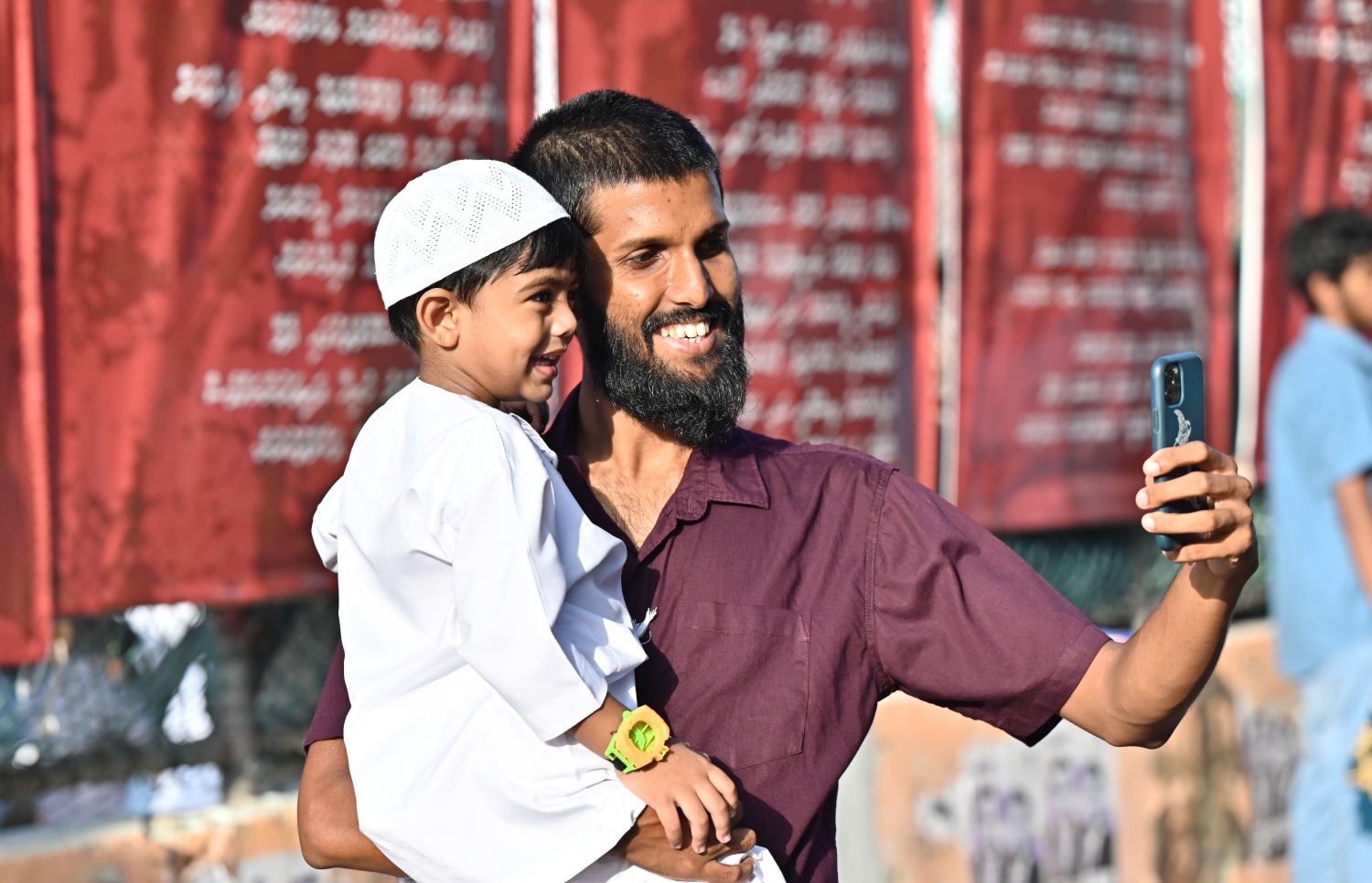 މާލޭގައި ބޭއްވި ފިިތުރު އީދު ނަމާދުގެ ބޮޑު ޖަމާއަތުގައި ބައިވެތިވުމަށް ގޮސްތިބި މީހަކު ކުޑަކުއްޖަކާއެކު ސެލްފީއެއް ނަގަނީ.-- ފޮޓޯ: ނިޝާން އަލީ /މިހާރު