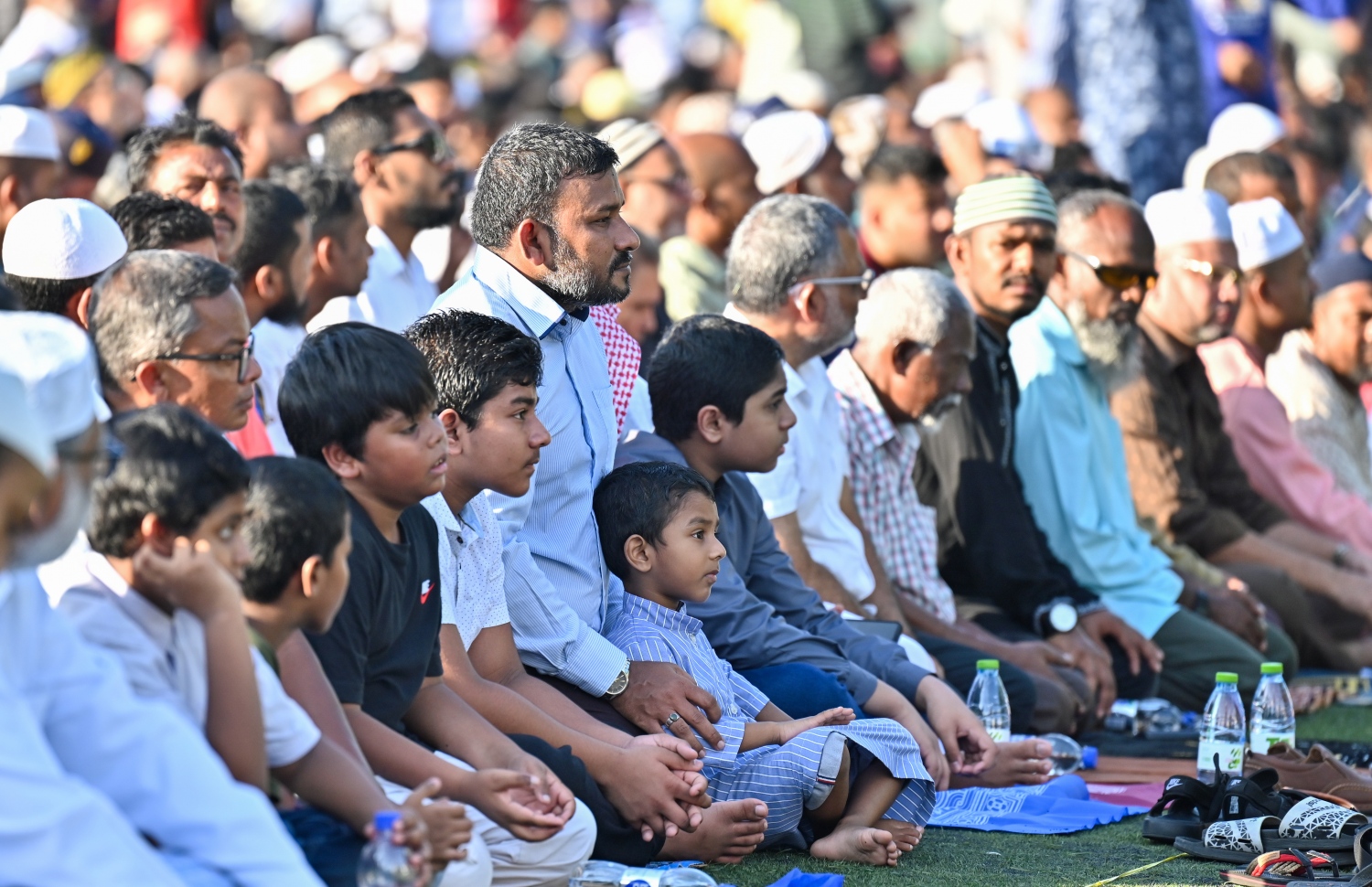 މާލޭގައި ބޭއްވި ފިިތުރު އީދު ނަމާދުގެ ބޮޑު ޖަމާއަތުގައި ބައިވެތިވުމަށް ކުޑަކުދިނއނާއި ބޮޑެތި މީހުން ނަމާދު ކުރާ ސަރަހައްދުގައި އިށީންދެލައިގެން.-- ފޮޓޯ: ނިޝާން އަލީ /މިހާރު