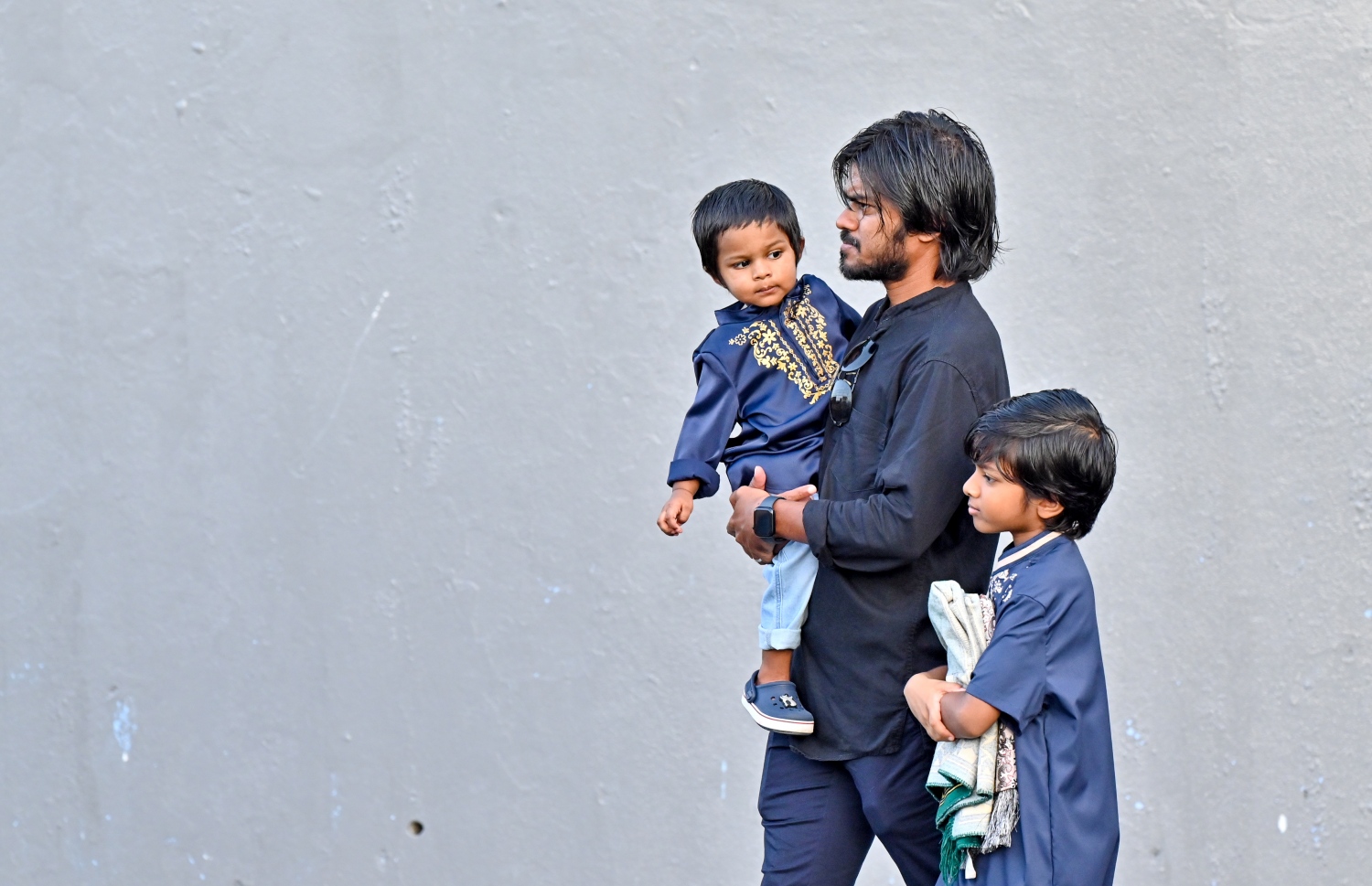 މާލޭގައި ބޭއްވި ފިިތުރު އީދު ނަމާދުގެ ބޮޑު ޖަމާއަތުގައި ބައިވެތިވުމަށް ކުޑަ ދެކުދިންނާއެކު މީހަކު ނަމާދު ކުރާ ސަރަހައްދަށް ދަނީ.-- ފޮޓޯ: ނިޝާން އަލީ /މިހާރު