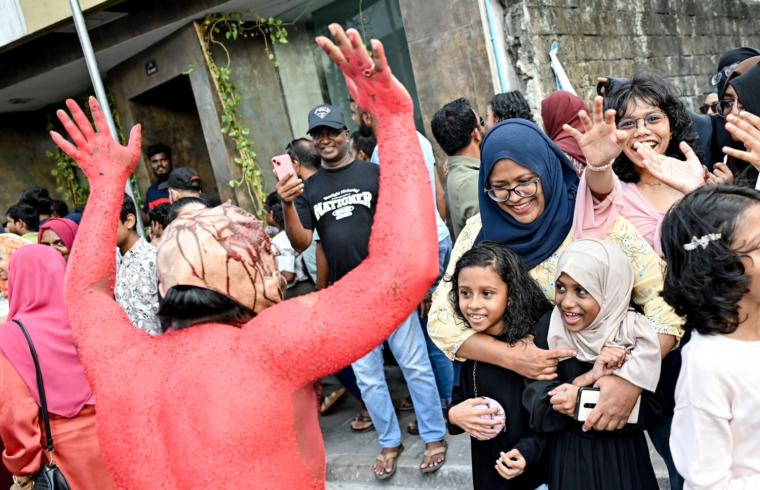 މާލި ޕެރޭޑް ބަލަން ތިބި ކުދިންތަކަކަށް މާއްޔެއް ހަނާ އަޅާލަނީ.--- ފޮޓޯ: ނިޝާން އަލީ | މިހާރު