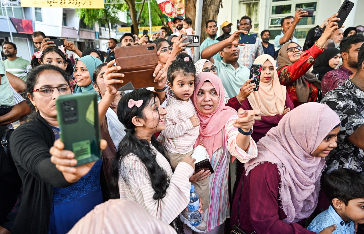 މާލި ޕެރޭޑް ބެލުމަށް މަޖީދީ މަގަށް ޖަމާވި ބައެއް މީހުން ފޯނުން މާލިތަކުގެ ފޮޓޯ ނަގަނީ.--- ފޮޓޯ: ނިޝާން އަލީ | މިހާރު