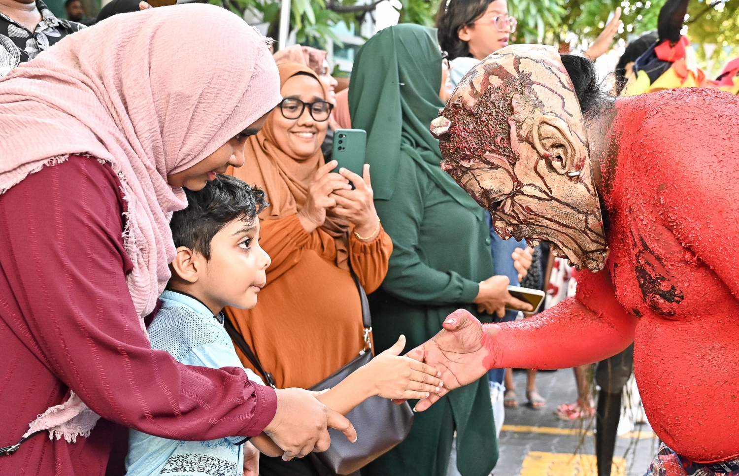 މާލި ޕެރޭޑްގައި ބައިވެރިވި މާއްޔެއް ކުއްޖަކާ ސަލާން ކުރަނީ.--- ފޮޓޯ: ނިޝާން އަލީ | މިހާރު