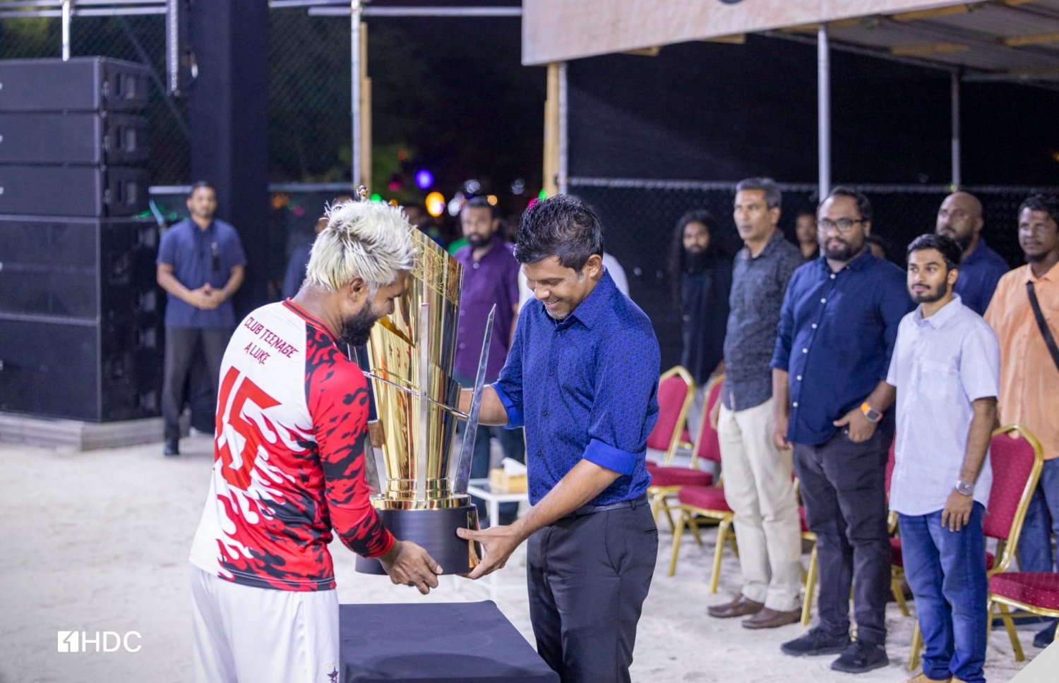 ޓީނޭޖްގެ ކެޕްޓަން އަހުމަދު މުހައްމަދު (އަންމަޑޭ) މުބާރާތުގެ ޗެމްޕިއަން ޓްރޮފީ، ނައިބު ރައީސް ހުސެއިން މުހައްމަދު ލަތީފާ ހަވާލު ކުރަނީ.-- ފޮޓޯ: އެޗްޑީސީ