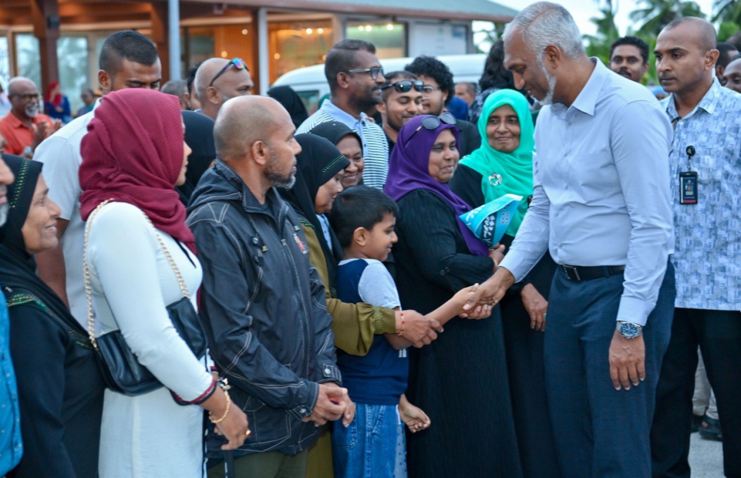 ރައީސް ޑރ. މުއިއްޒު އައްޑުއަށް ވަޑައިގަތުމުން އެމަނިކުފާނަށް މަރުހަބާ ދެންނެވުމަށް ގަން އެއާޕޯޓަށް ގޮސް ތިބި މީހުންގެ ތެރެެއިން ކުޑަކުއްޖާ ސަލާަމް ކުރައްވަނީ -- ފޮޓޯ: ޕީއެންސީ